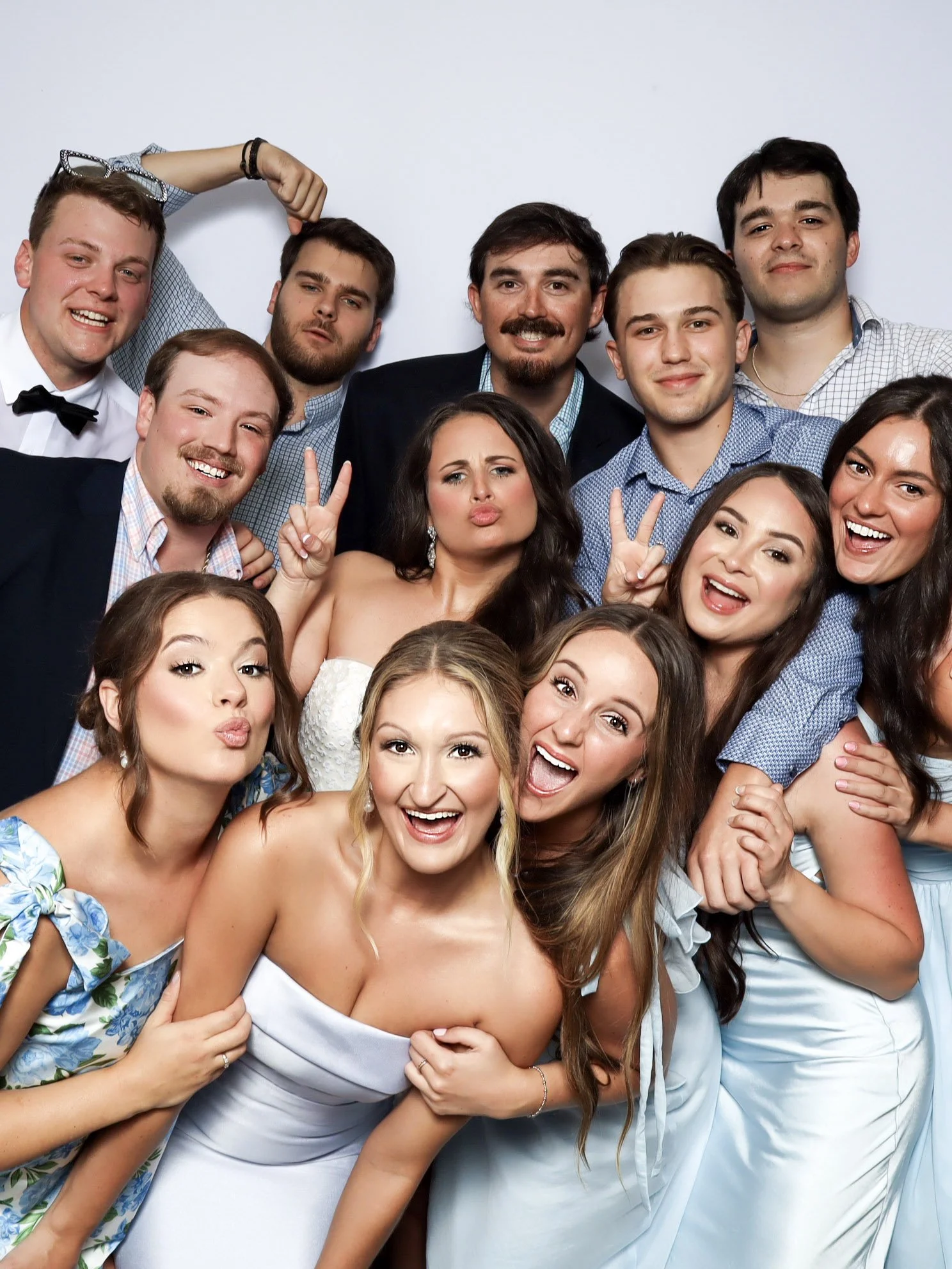 Group of people celebrating at a party, dressed in formal attire, smiling and posing together.