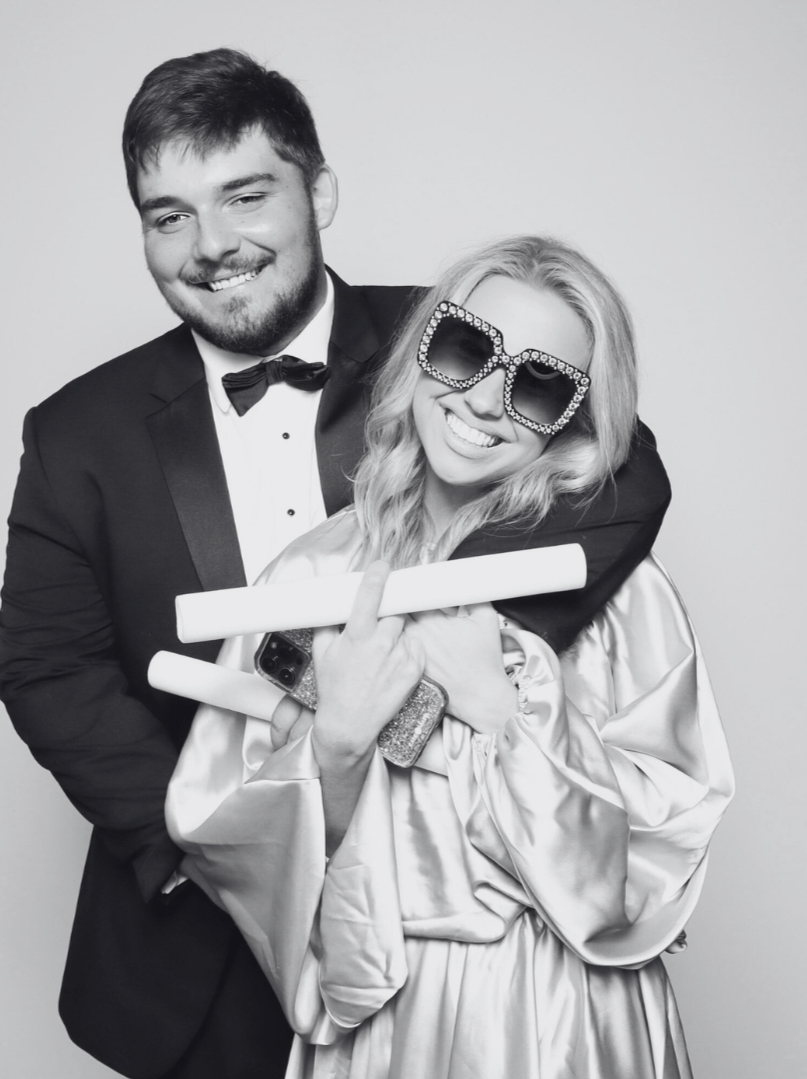 Wedding guests smiling at a Booth & Bash Co. black and white glam photo booth setup during a wedding celebration near Memphis, Tennessee. Shows professional event entertainment with unlimited digital captures and glam filter styling.