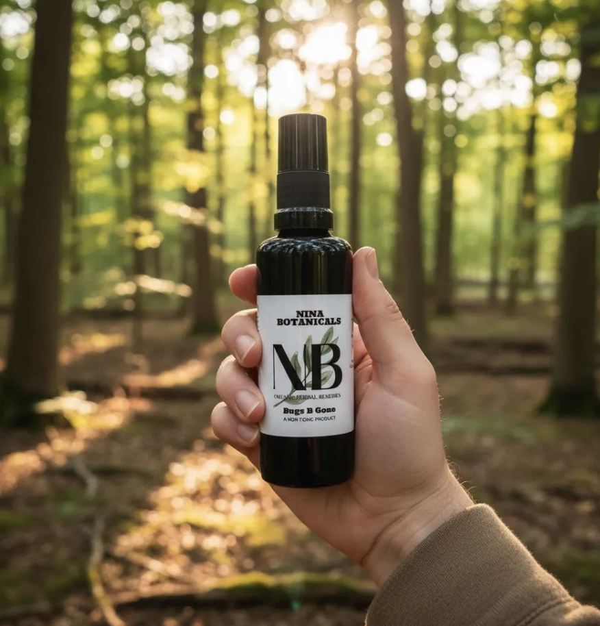 Hand holding bug spray outdoors in forest setting