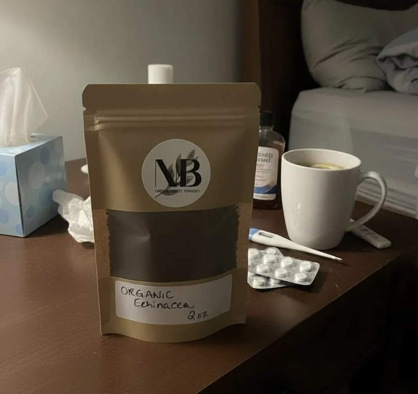 Stand-up bag of organic echinacea purpurea powder on nightstand next to thermometer for immune and flu support