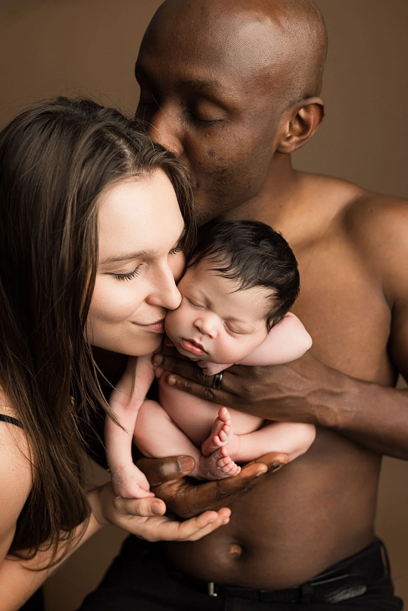 Parents kissing their newborn baby during a studio newborn photography session with a Seattle newborn photographer