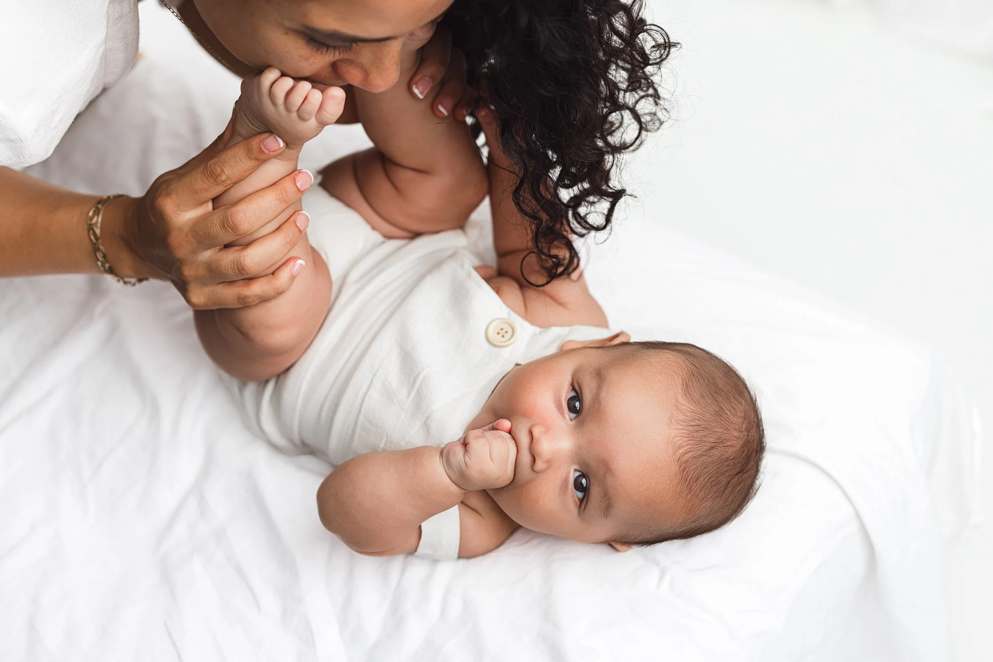 Mother gently holding her baby during a milestone session in a studio in Lake Tapps, captured by a Lake Tapps photographer