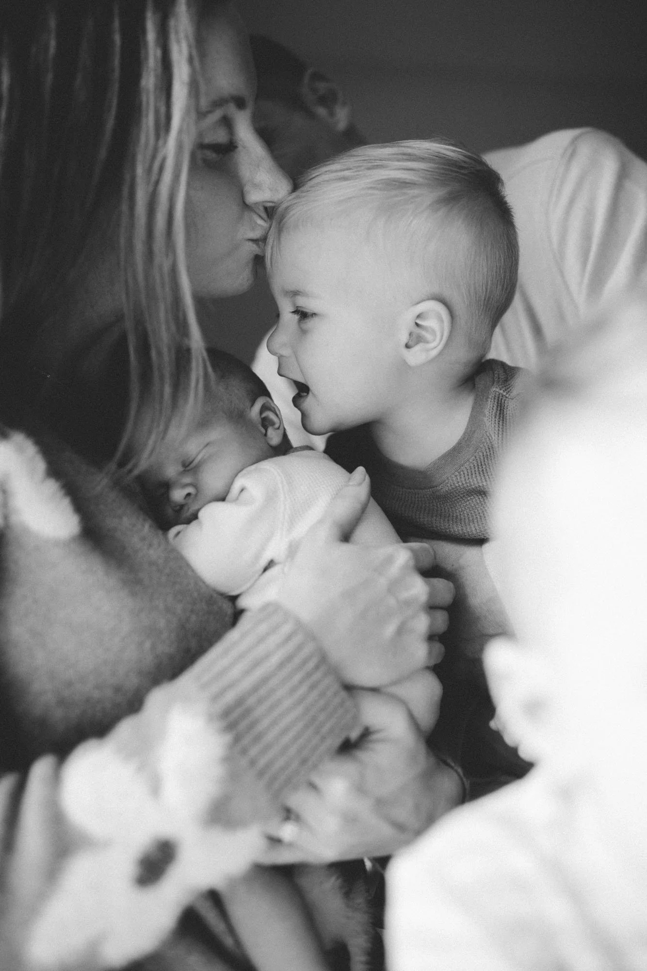 Close-up of a newborn’s tiny feet resting in their parents’ hands during a cozy in-home newborn photography session in Seattle.