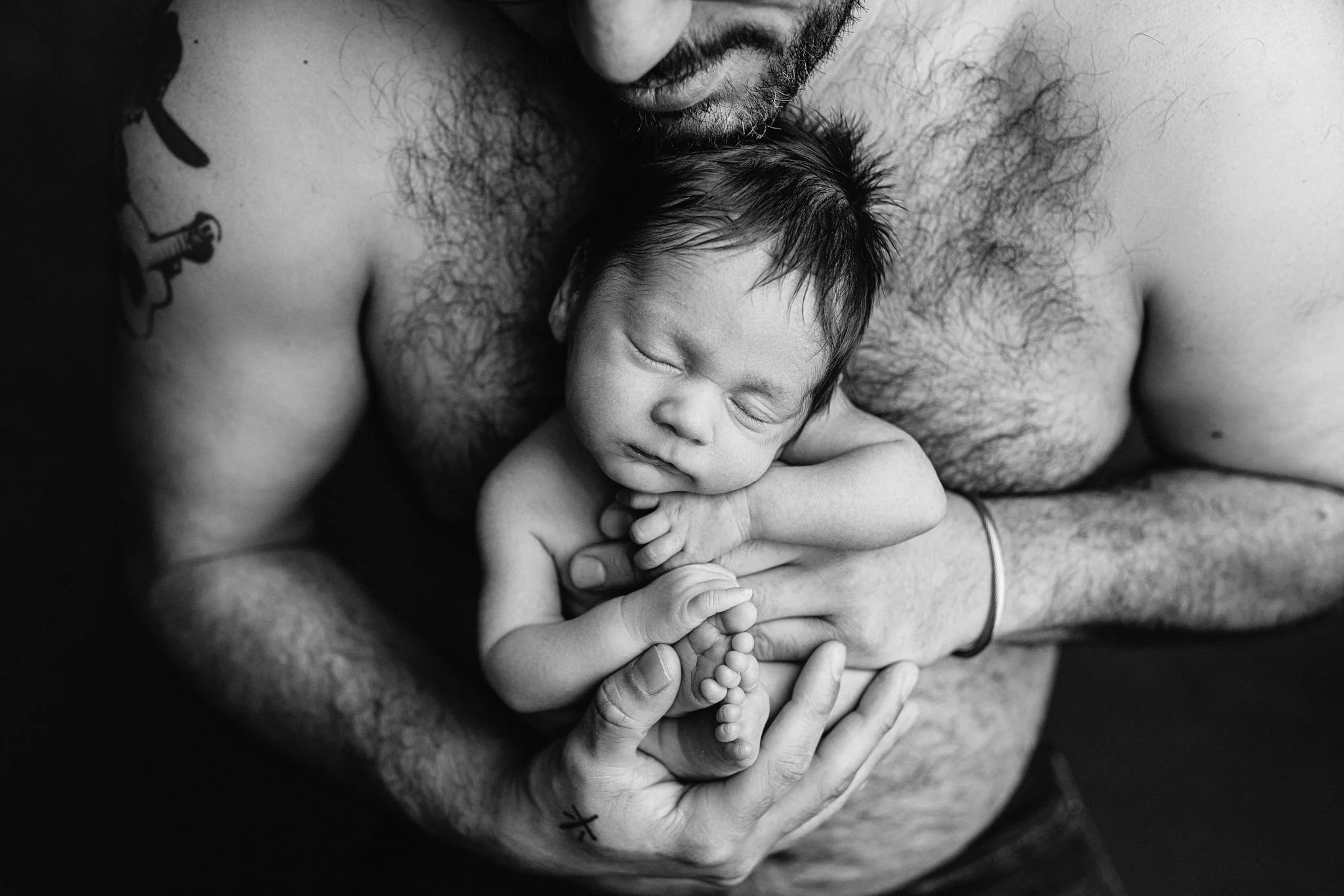 Father holding his sleeping newborn baby in a timeless black and white portrait – Seattle newborn photographer