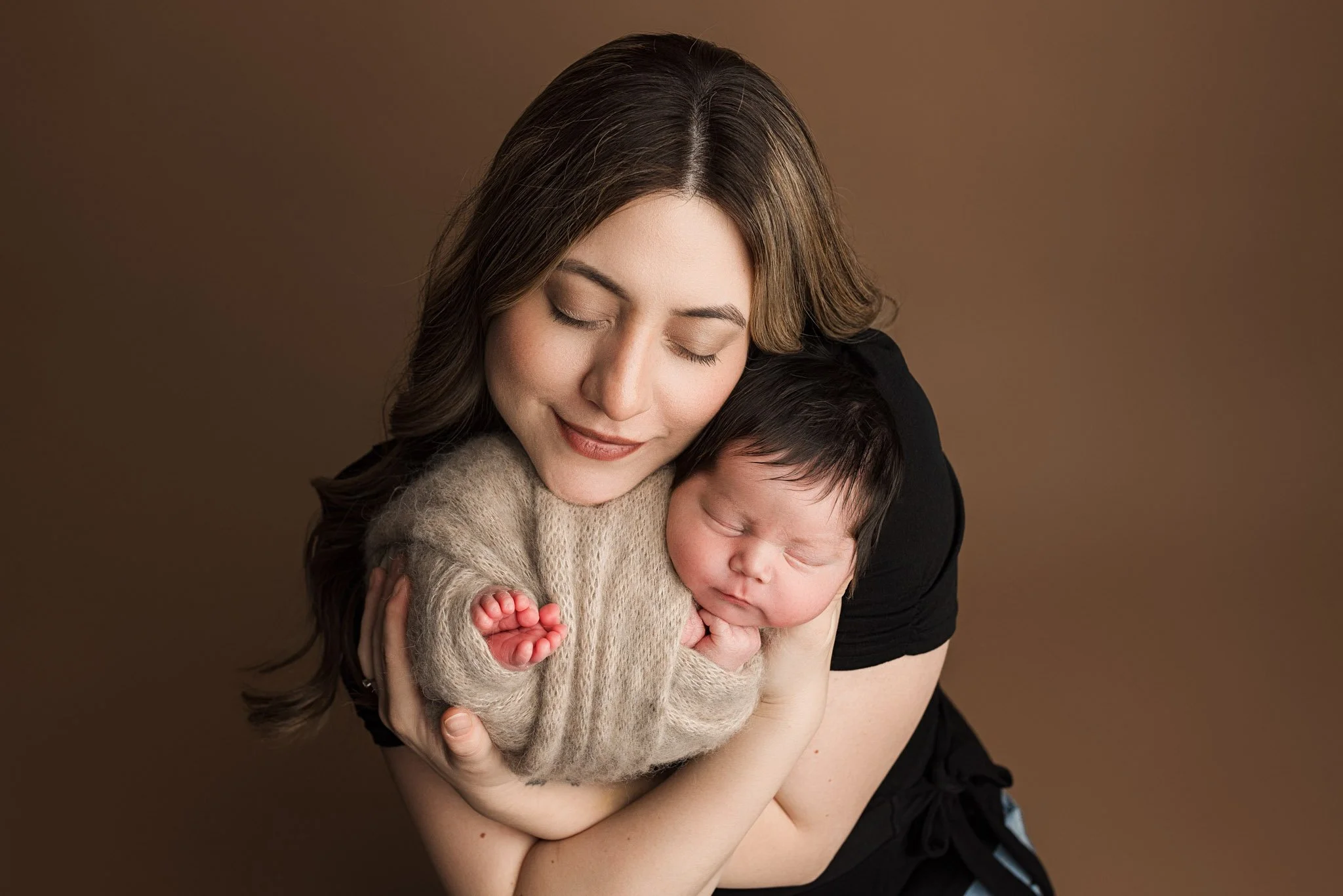 Mother holding her newborn baby during a studio newborn photography session in Lake Tapps Washington