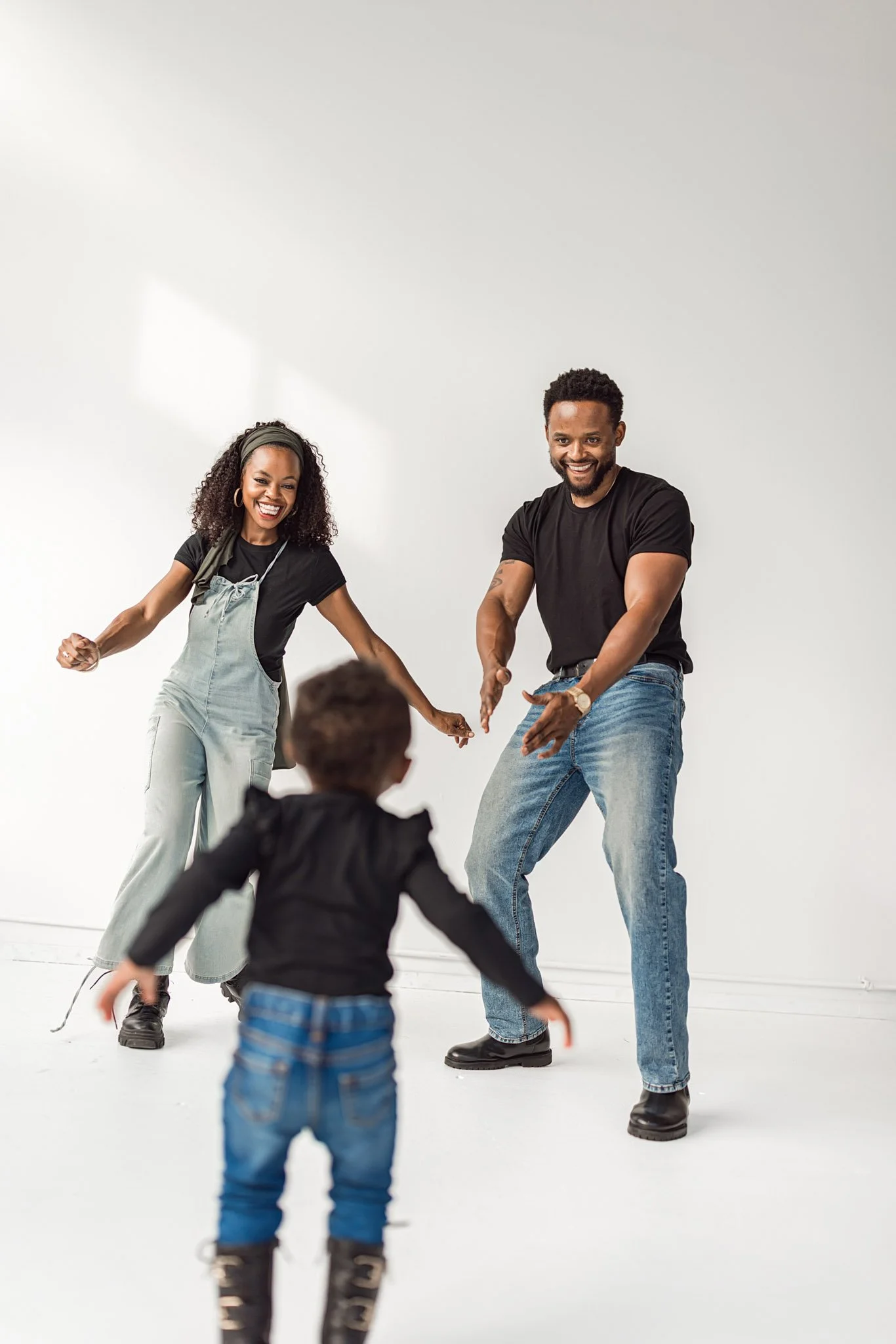 Playful family moment during a Seattle natural light studio family photography session with parents welcoming their toddler.