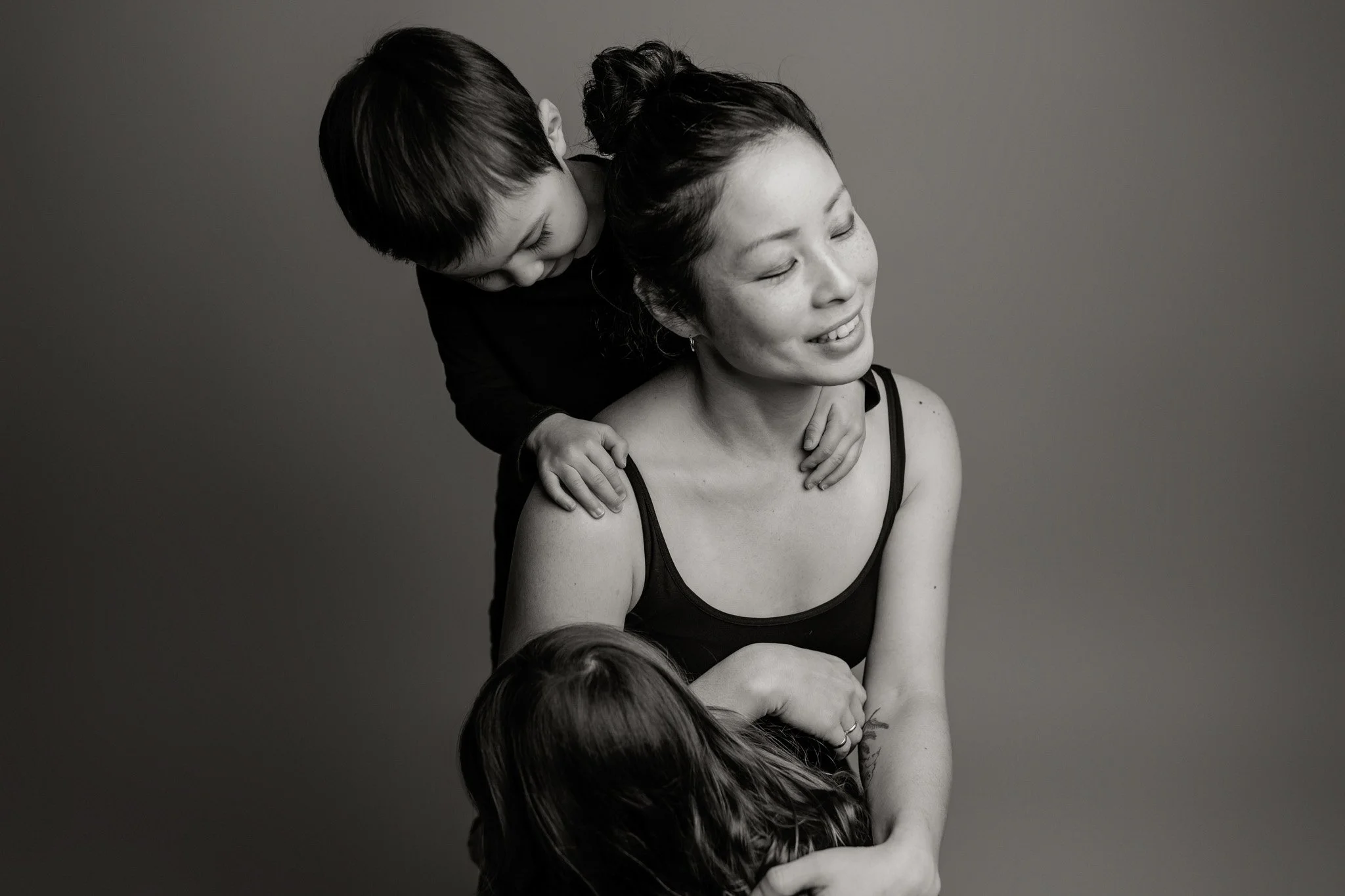 Atsumi Sullivan with two children embracing in a timeless black and white portrait, Seattle family photographer