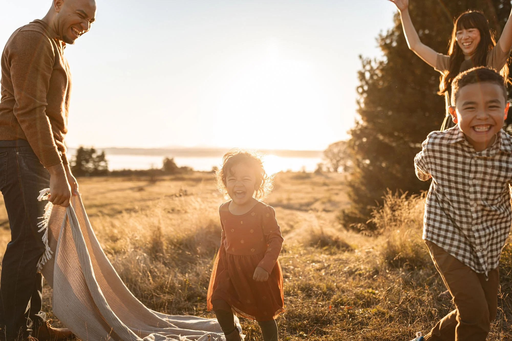 Bellevue family photography session at sunset with parents and children laughing and playing outdoors