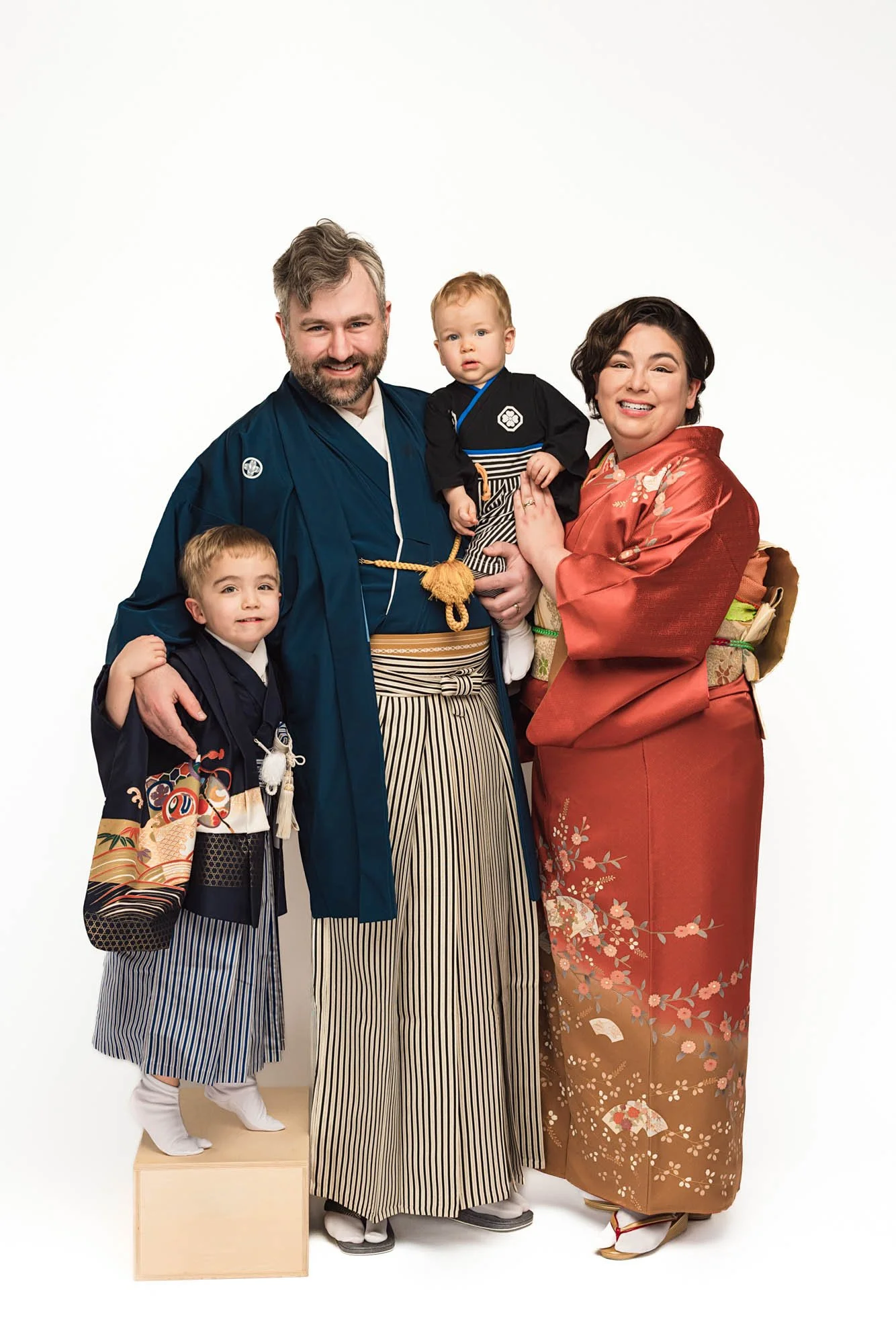 Family of four wearing traditional Japanese kimono, studio family portrait with parents and young children – Seattle kimono family photography session