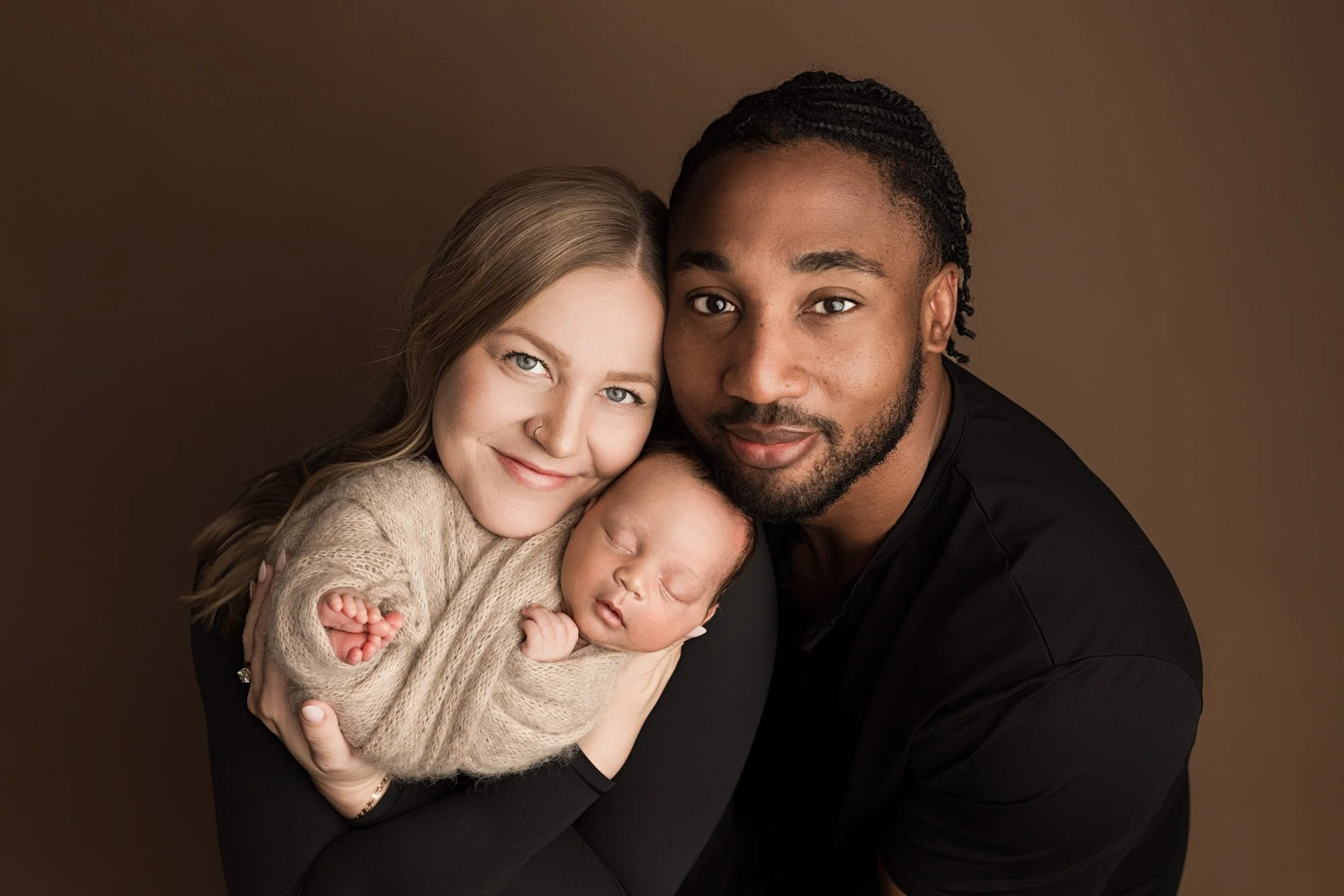 Parents holding their sleeping newborn baby during a Seattle studio photography session