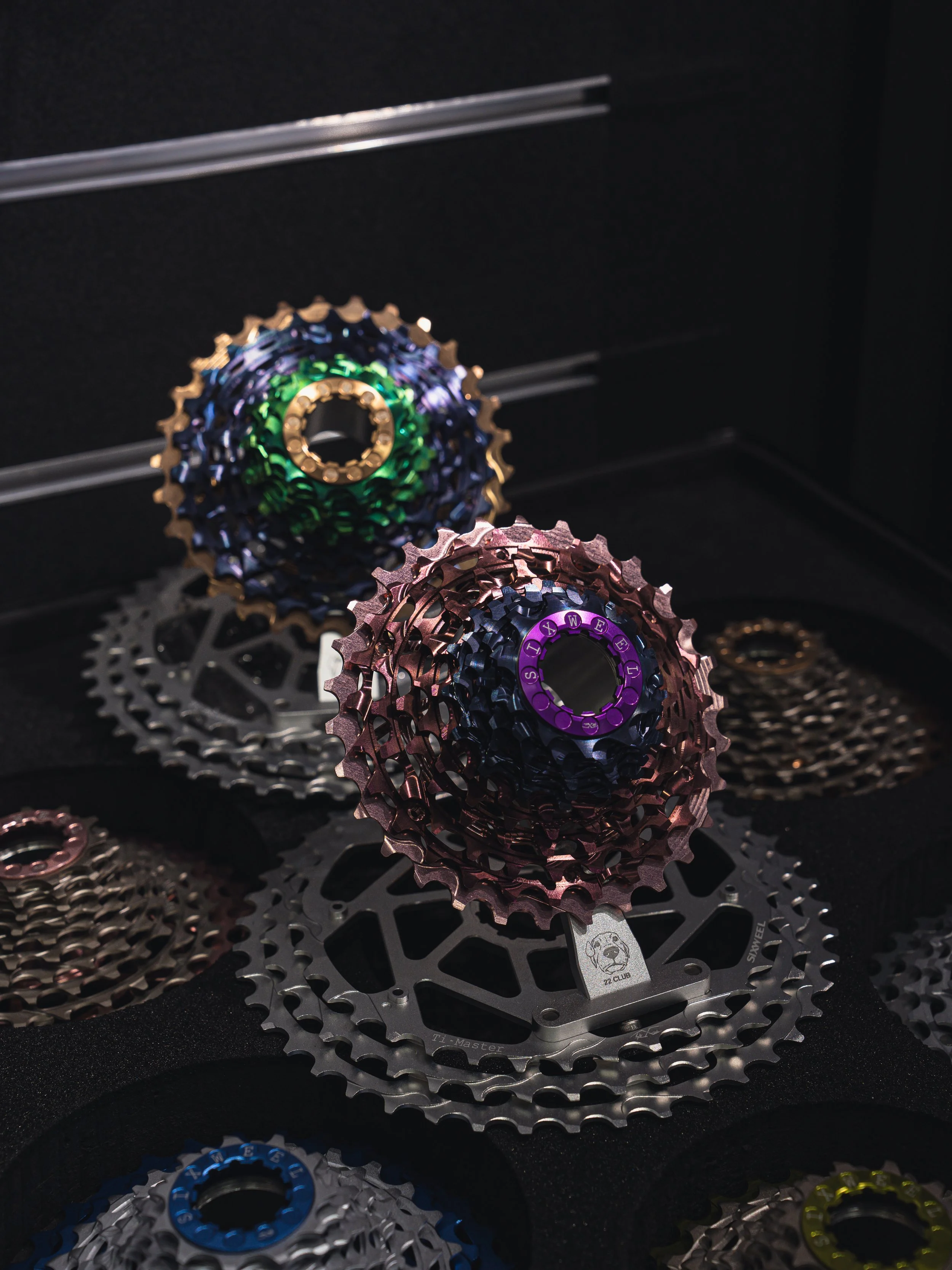 Close-up of a silver bicycle cassette on a wooden surface.