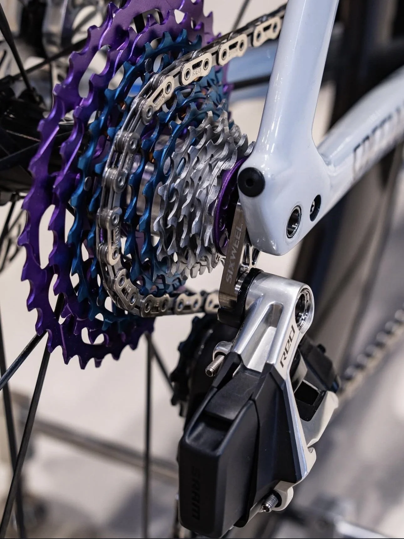 Close-up of a silver bicycle cassette on a wooden surface.