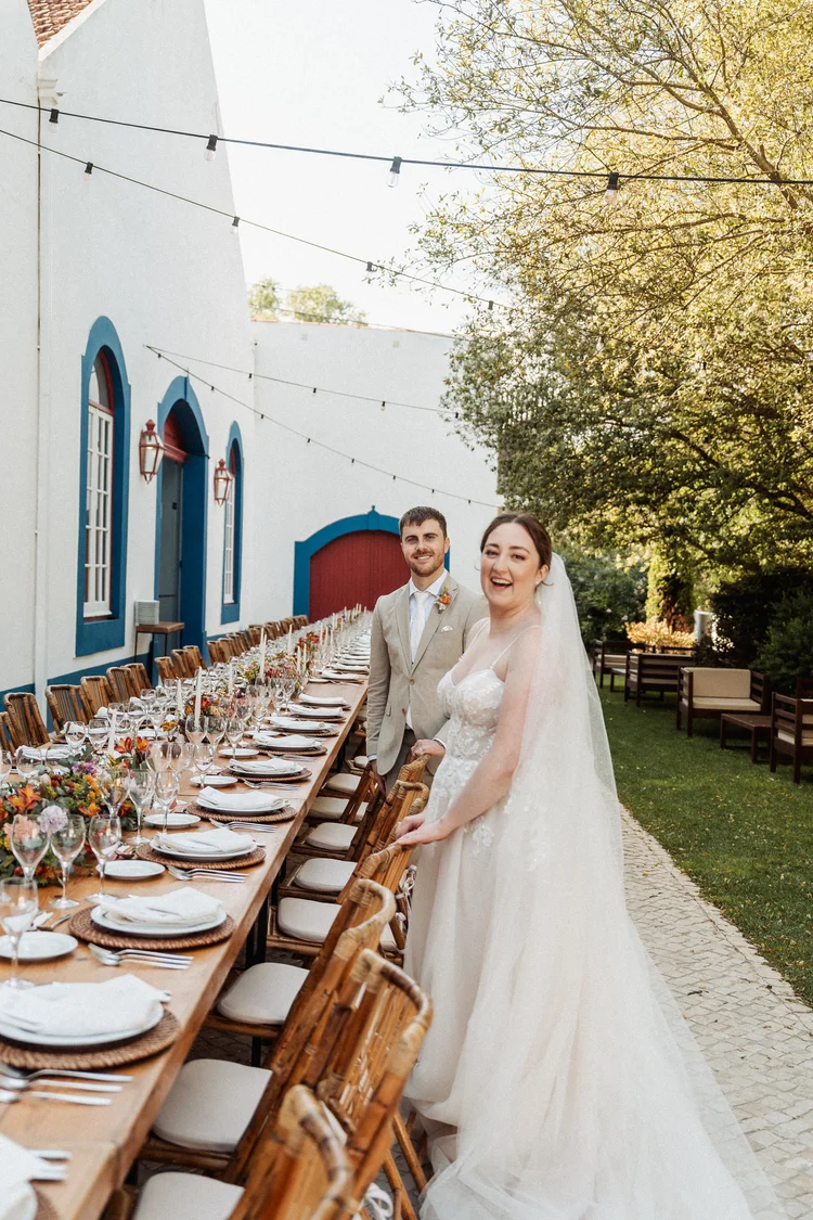 Couple at a long outdoor wedding table