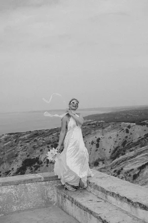 Bride standing on stone steps with her bouquet