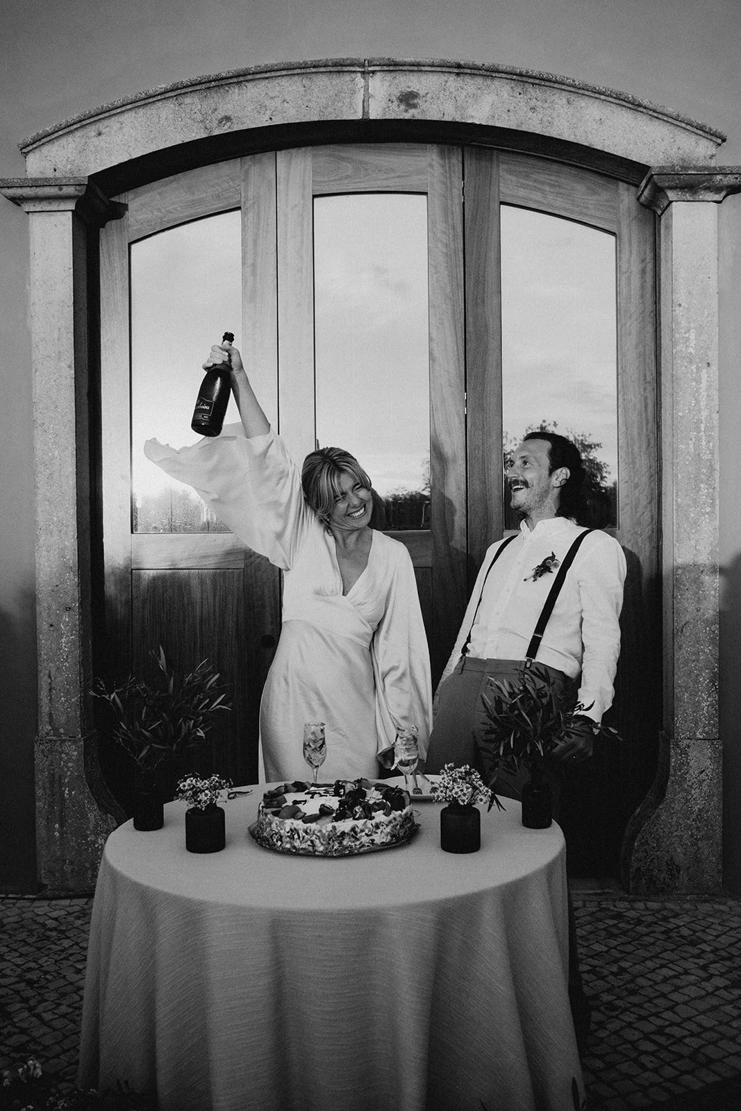 Bride and groom sharing a laugh while cutting wedding cake at Solar do Paço