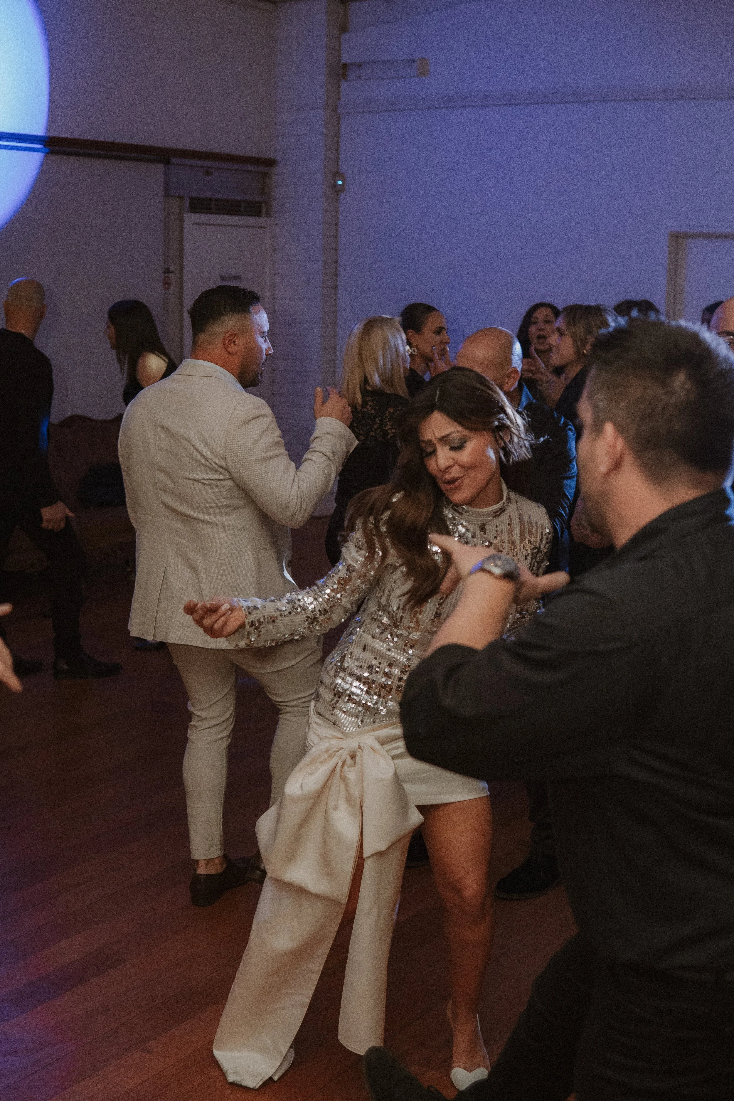 People dancing and having fun at a party or celebration in a dimly lit room. yarra valley and Melbourne wedding photographer