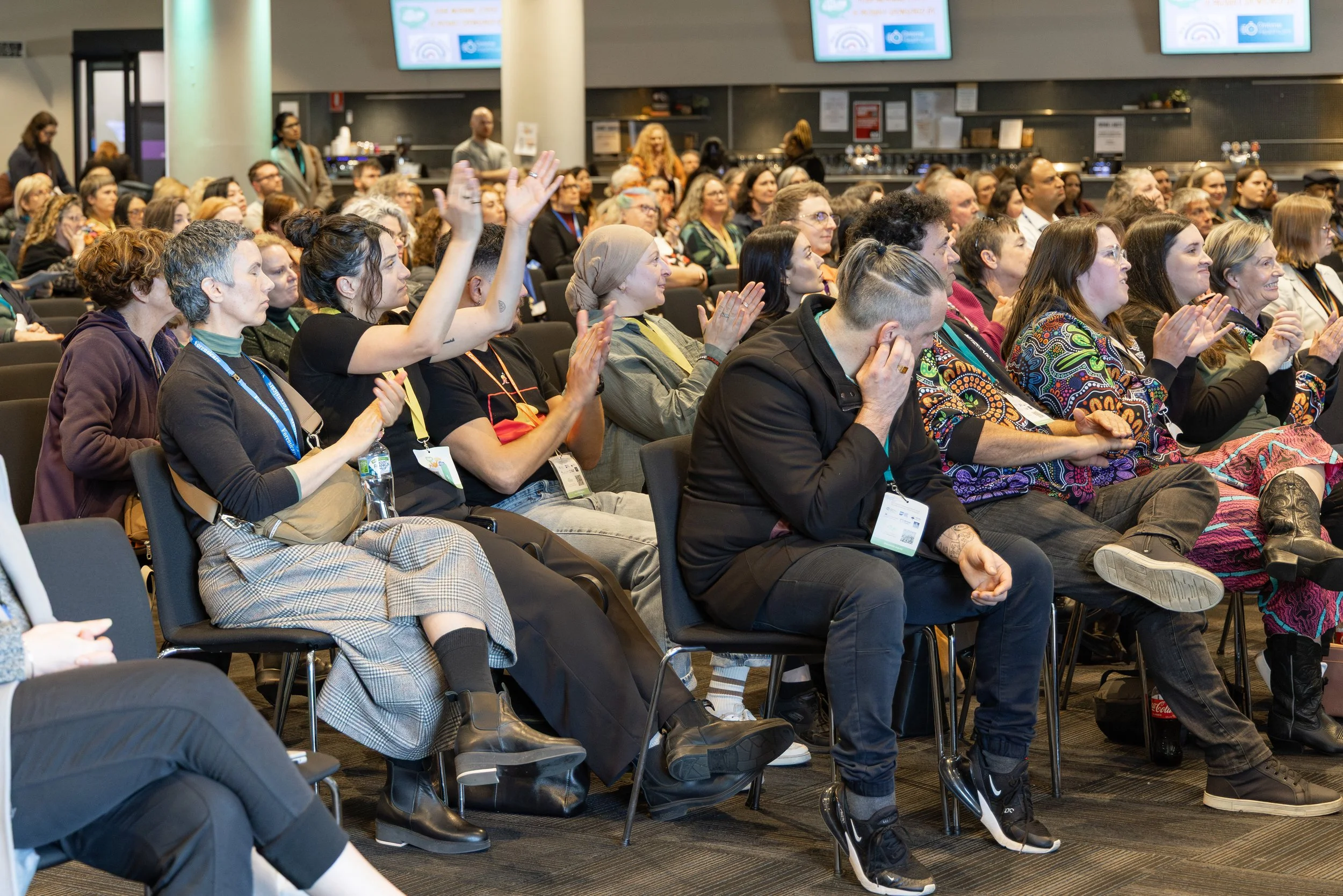 A colour image of a crowd clapping at a business conference