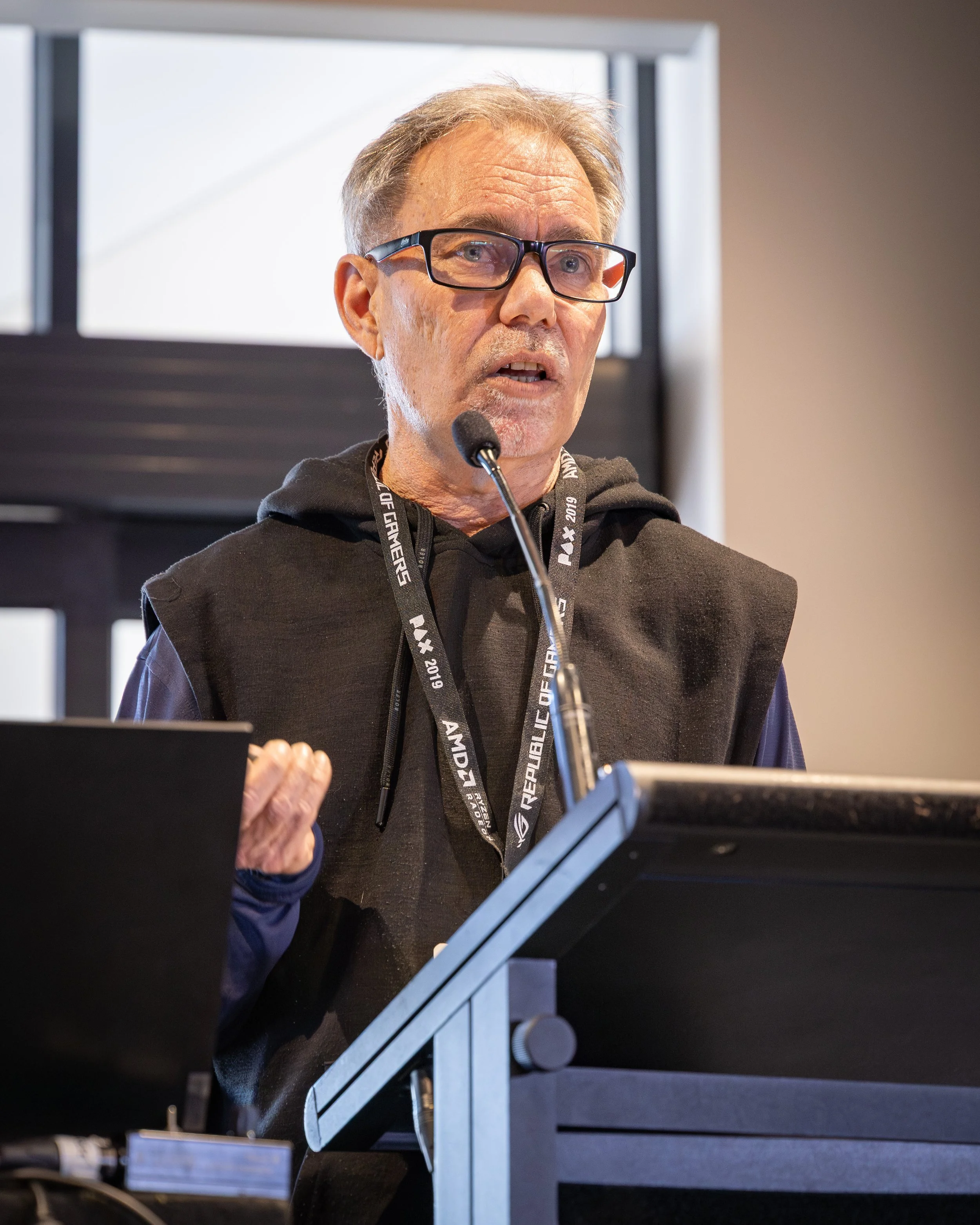 A colour image of a man behind a lectern at a business conference 