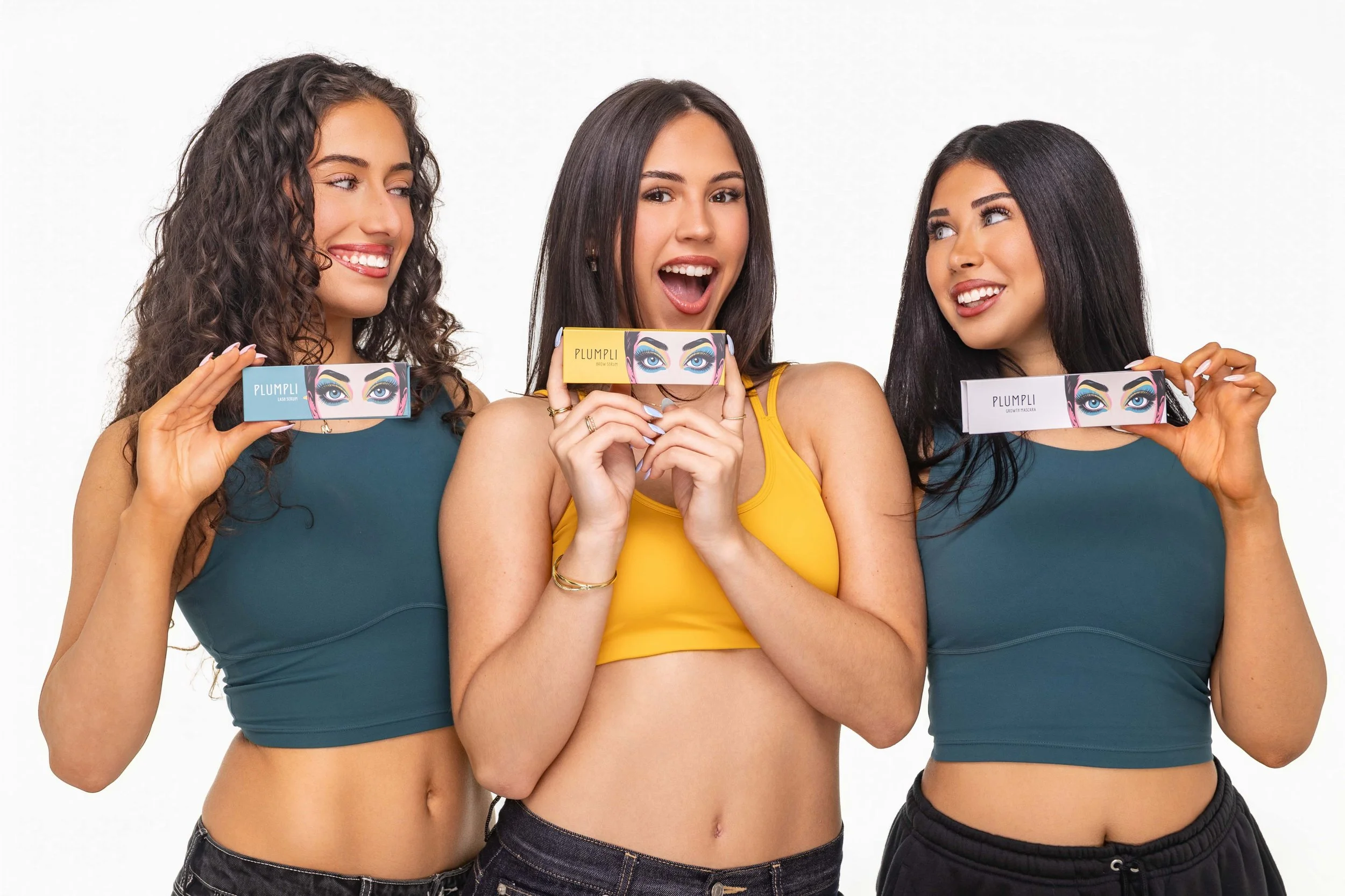 A group shot of three young models promoting eye make up on a white background 
