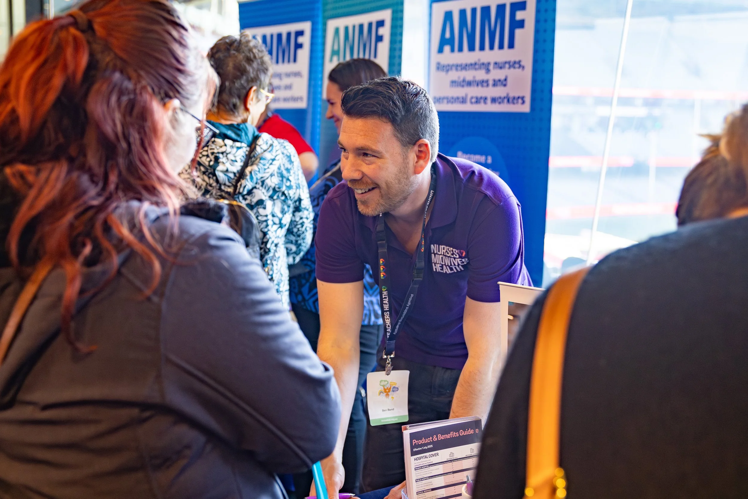 A colour image of people engaging at a stall at a business event