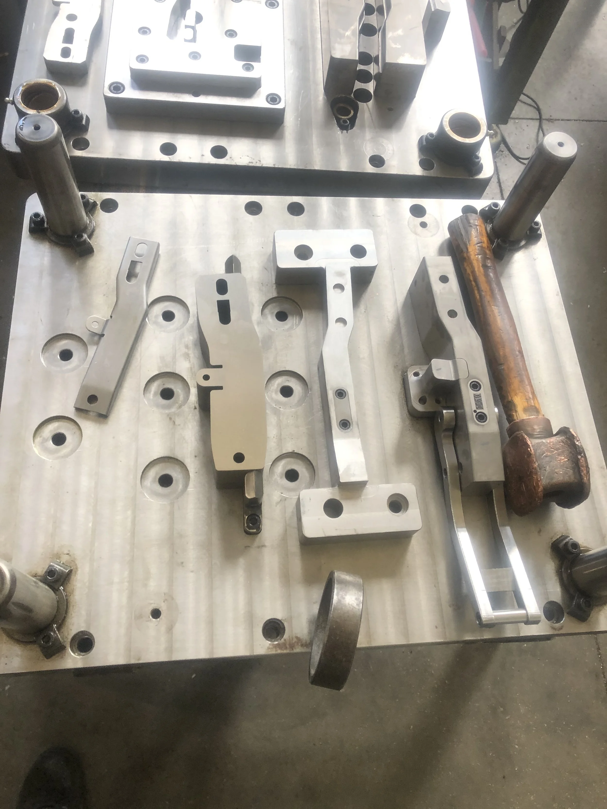 Parti metallici e strumenti di lavoro su un banco da lavoro, attrezzi e componenti in metallo