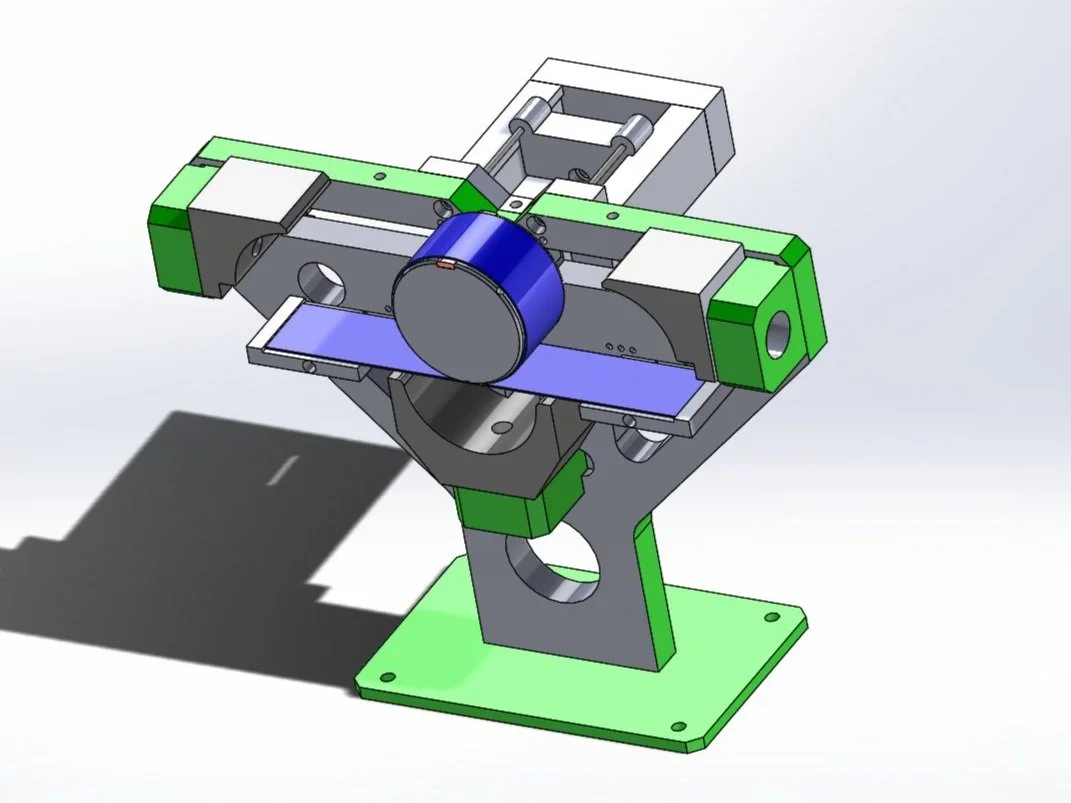 Modello 3D di una macchina ottica con componenti metallici e colorati, inclusi una parte blu, rotta e vari supporti.