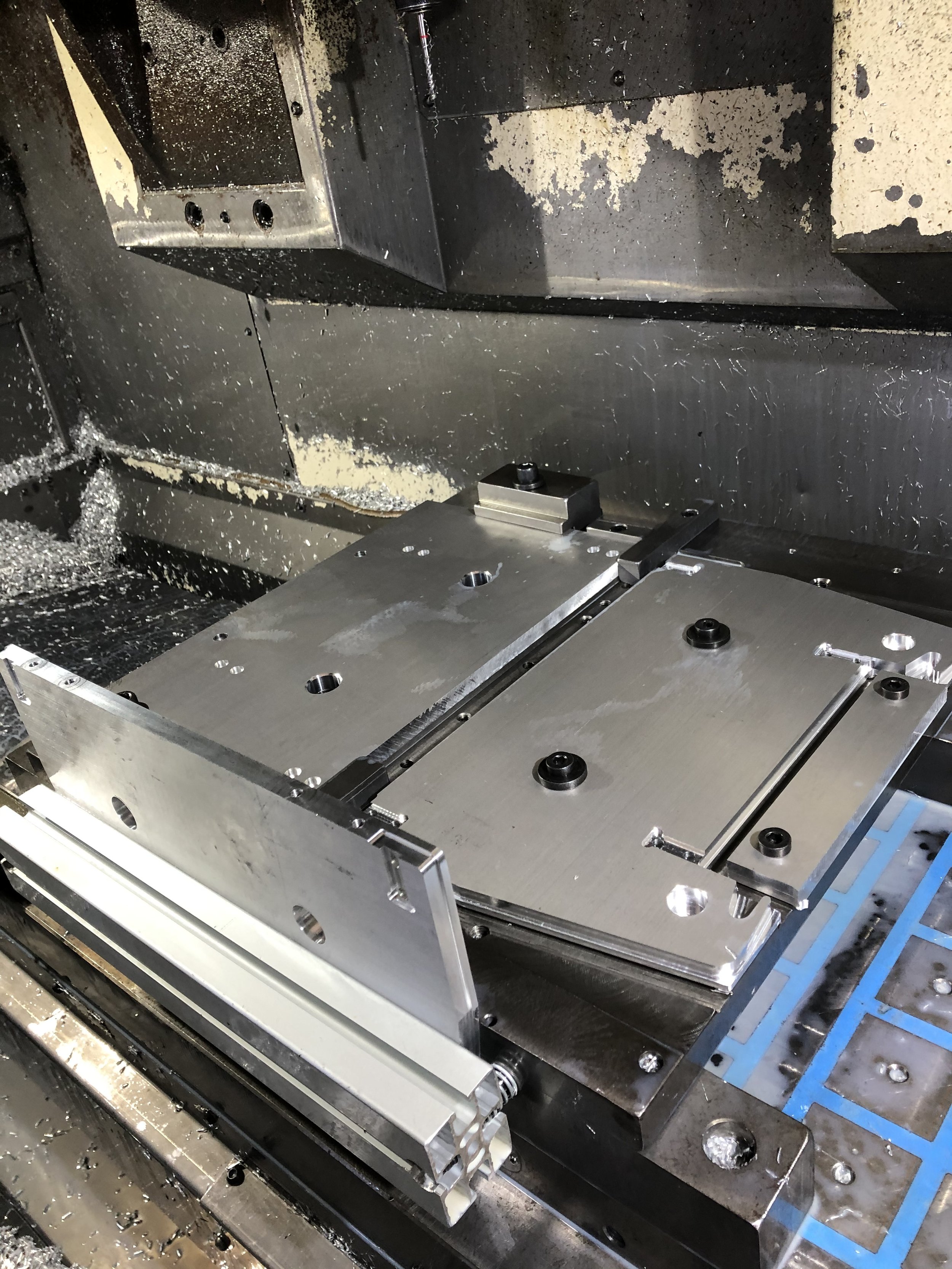Componenti metallici di una macchina utensile CNC, con parti del mandrino e guide lineari.