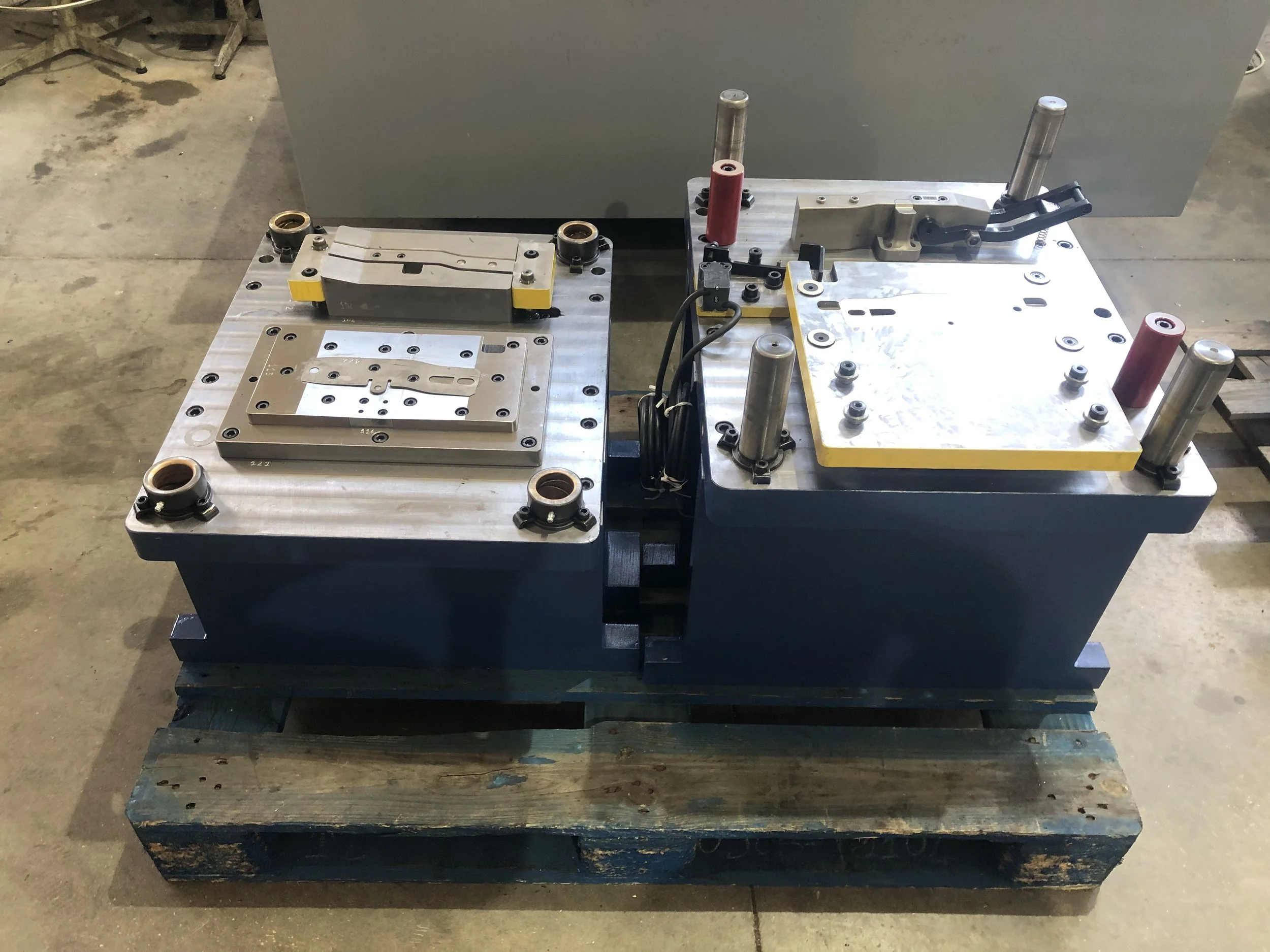 Macchina di precisione industriale con piastre metalliche, viti e componenti meccanici