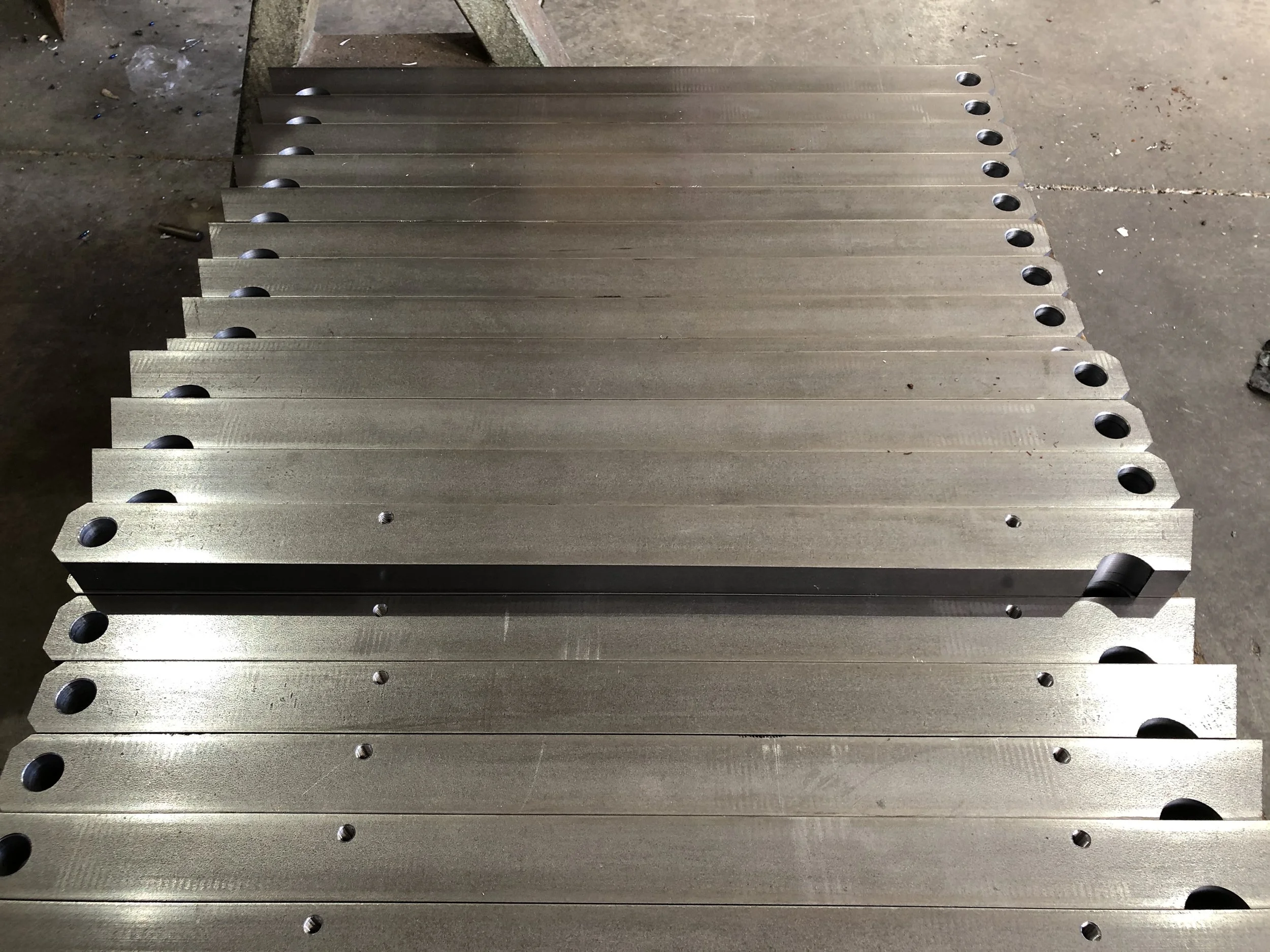 Piastra di metallo con fori, disposta su una superficie di calcestruzzo