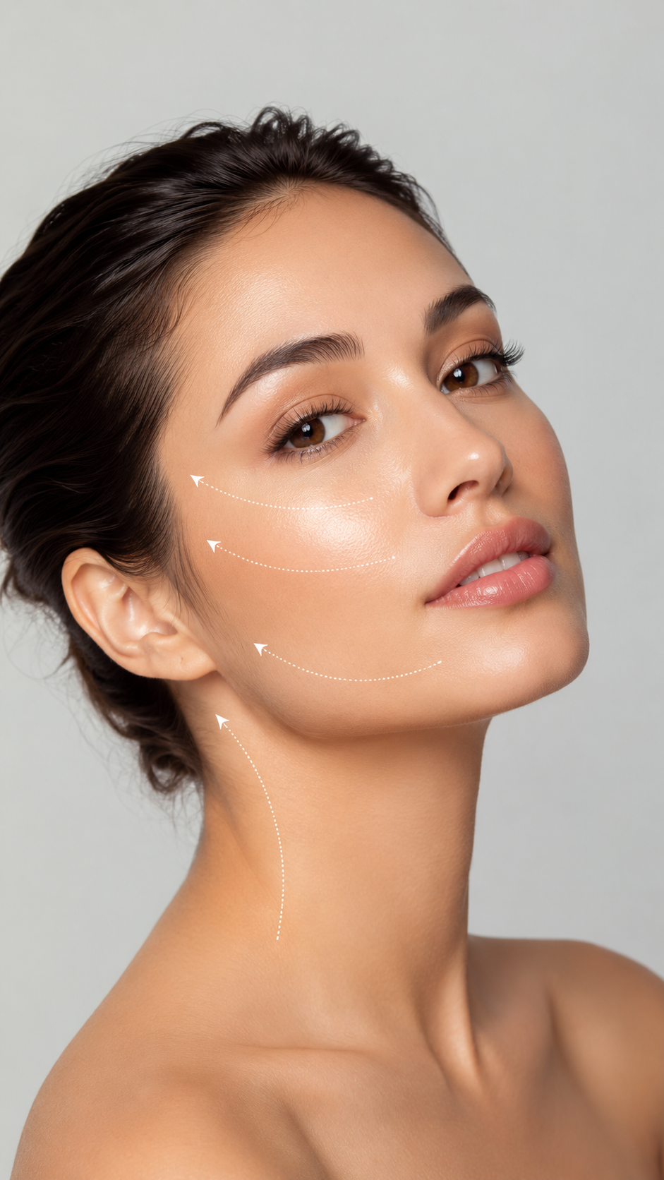 Close-up of a young woman with smooth skin, light makeup, and dark hair pulled back. White dotted lines and arrows indicate potential areas for cosmetic or skincare treatment on her cheek, jawline, and neck.