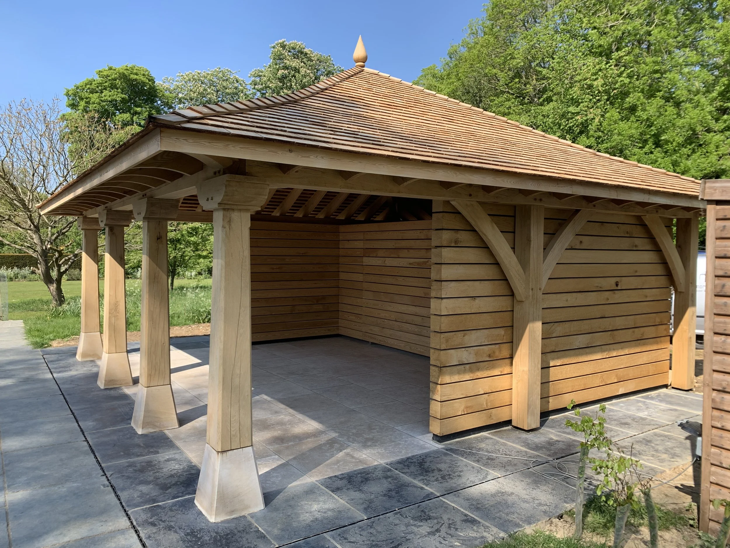 Oak and Siberian larch pool house, with larch roof shingles and decorative finial.