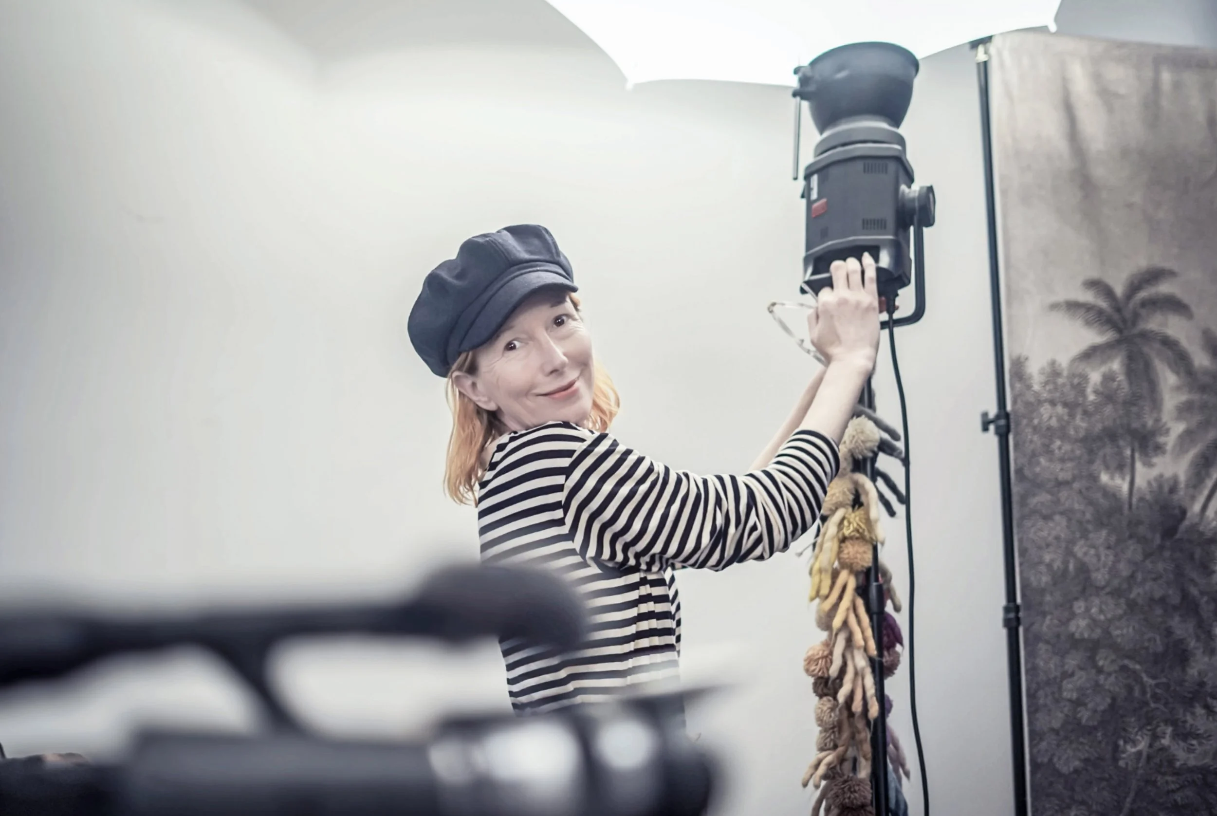 BELLE STEWART - MEDIA LITERACY EDUCATOR  adjusting studio lighting in a photography studio