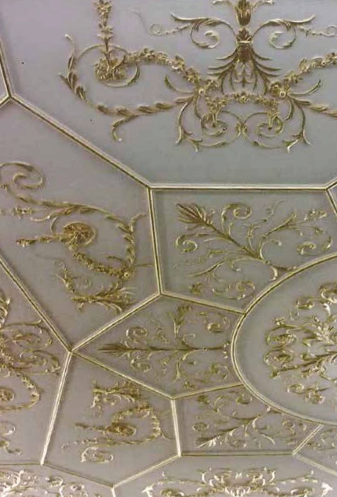 Décoration de plafond ornée de motifs en relief dorés dans des formes hexagonales.