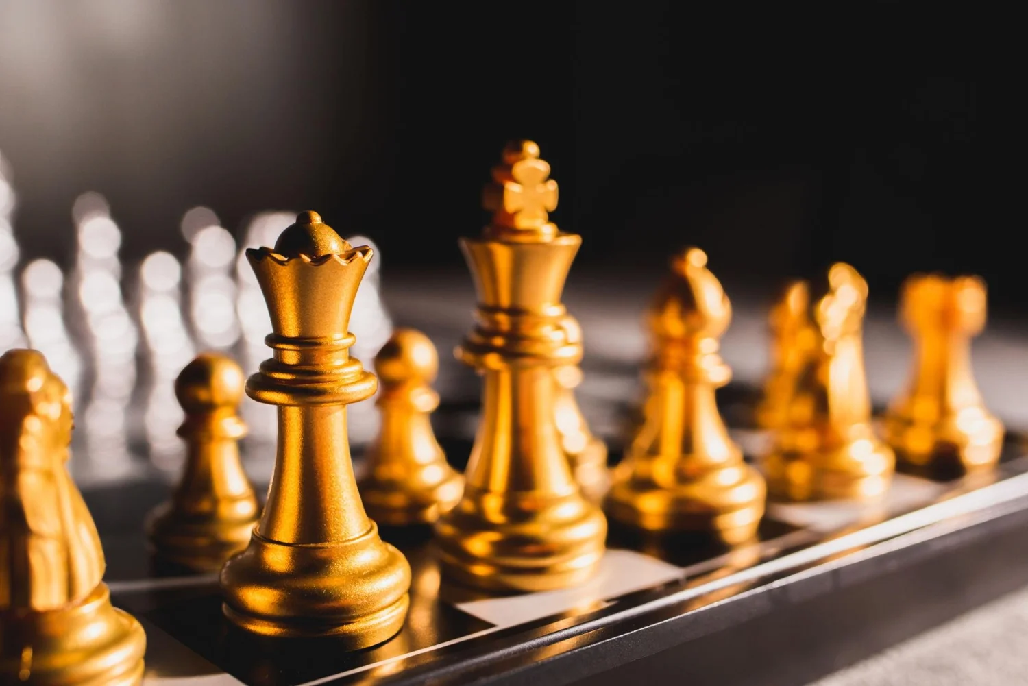 Goldene Schachfiguren als Symbol für das Zusammenspiel verschiedener Bereiche im Business
