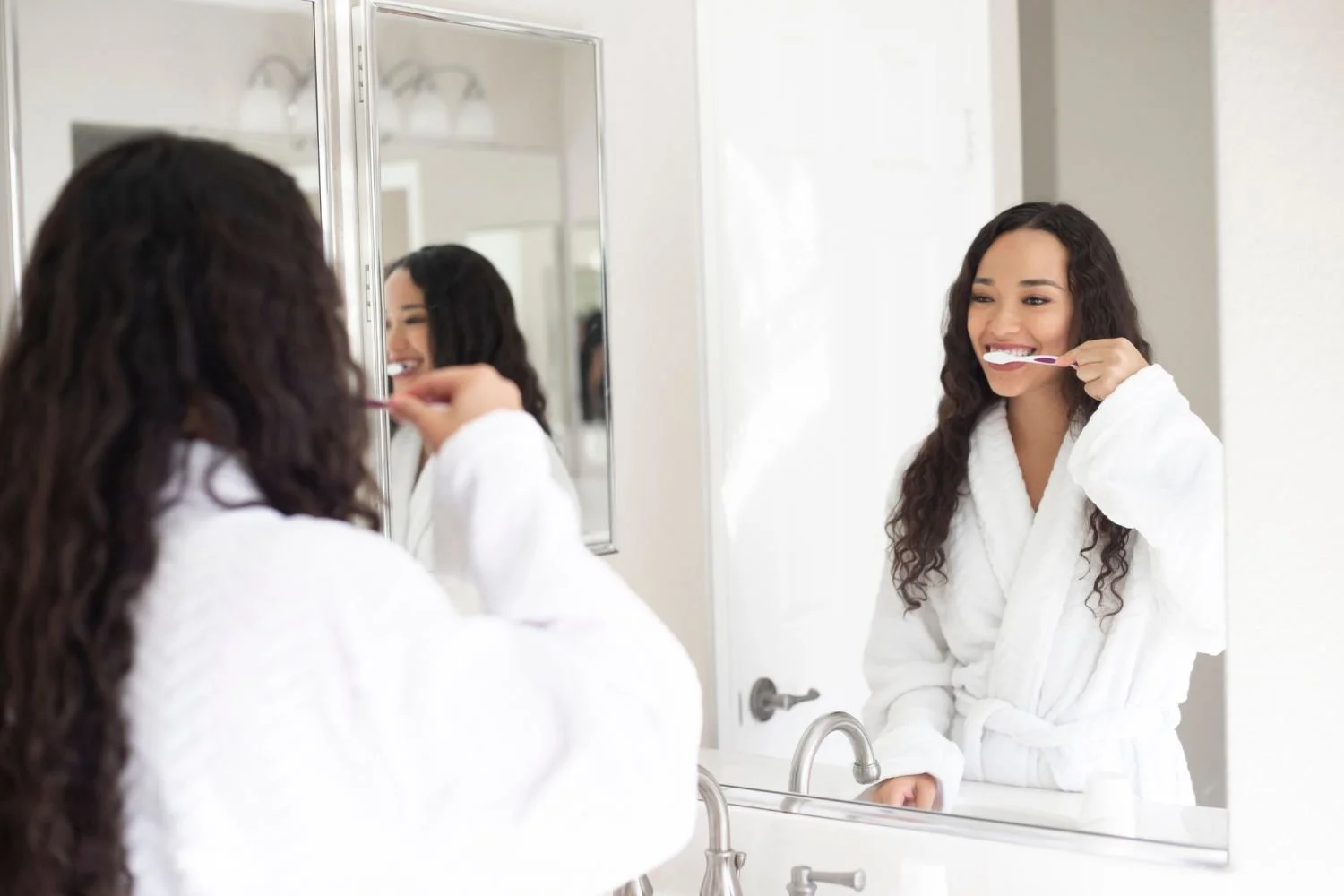 Woman brushing teeth to preserve her natural teeth.