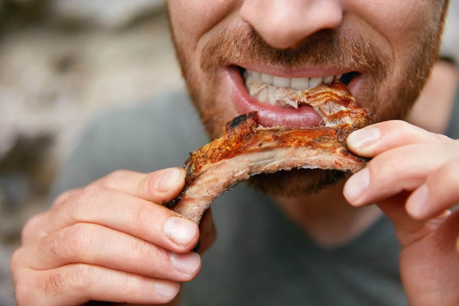 Man biting into pizza showcasing uneven chewing patterns.