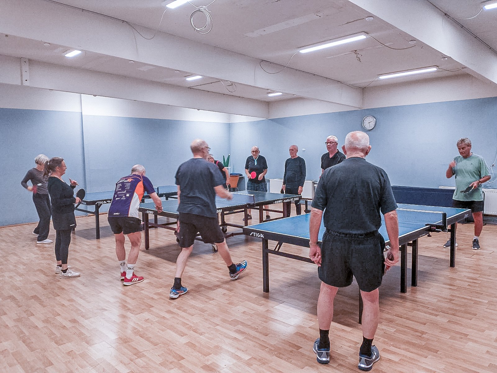 Mennesker spiller bordtennis i en bordtennisklub.