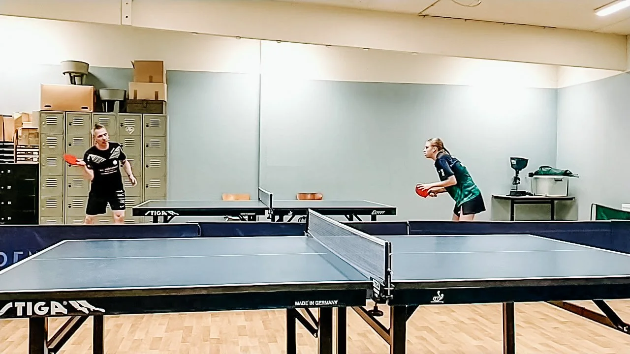 To personer spiller bordtennis i en sportsklub.