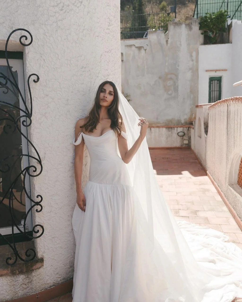 For her Sicilian castle wedding, model and entrepreneur Dominique Elissa Faludi chose to honour her roots with a gown designed in Sydney by J.Andreatta Bridal Couture.

The off-shoulder silhouette, corseted bodice, and sculptural drapery carried the 