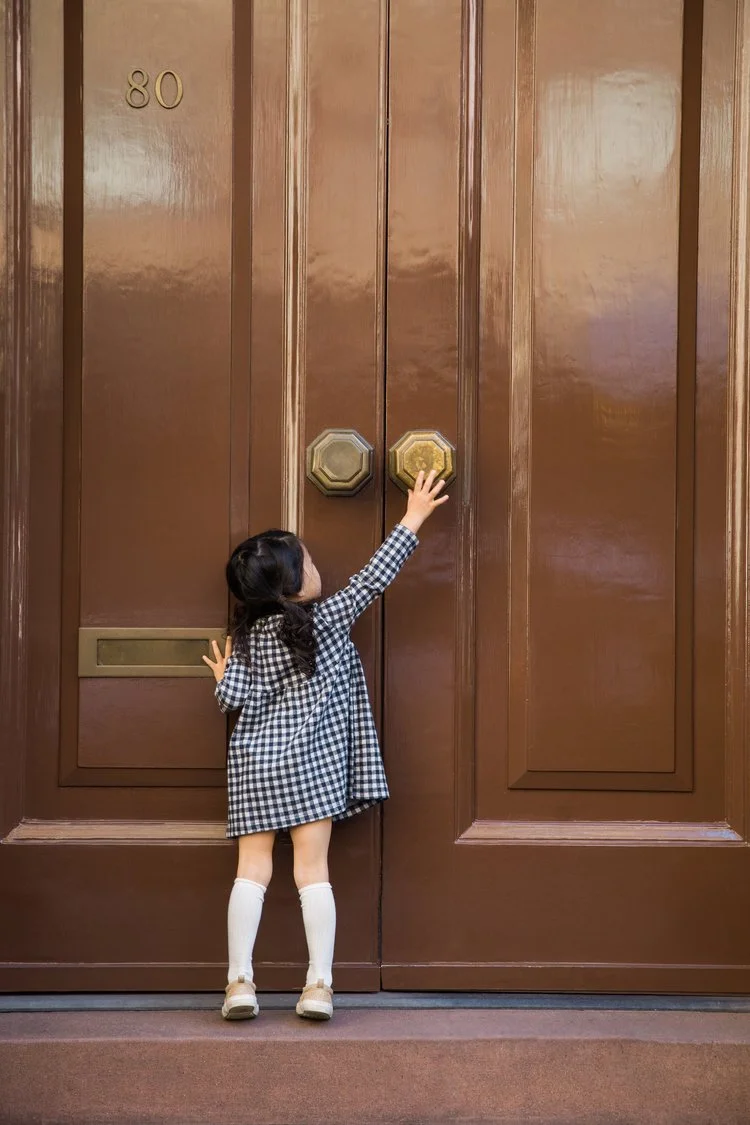 Small child with architectural detail large door cute girl