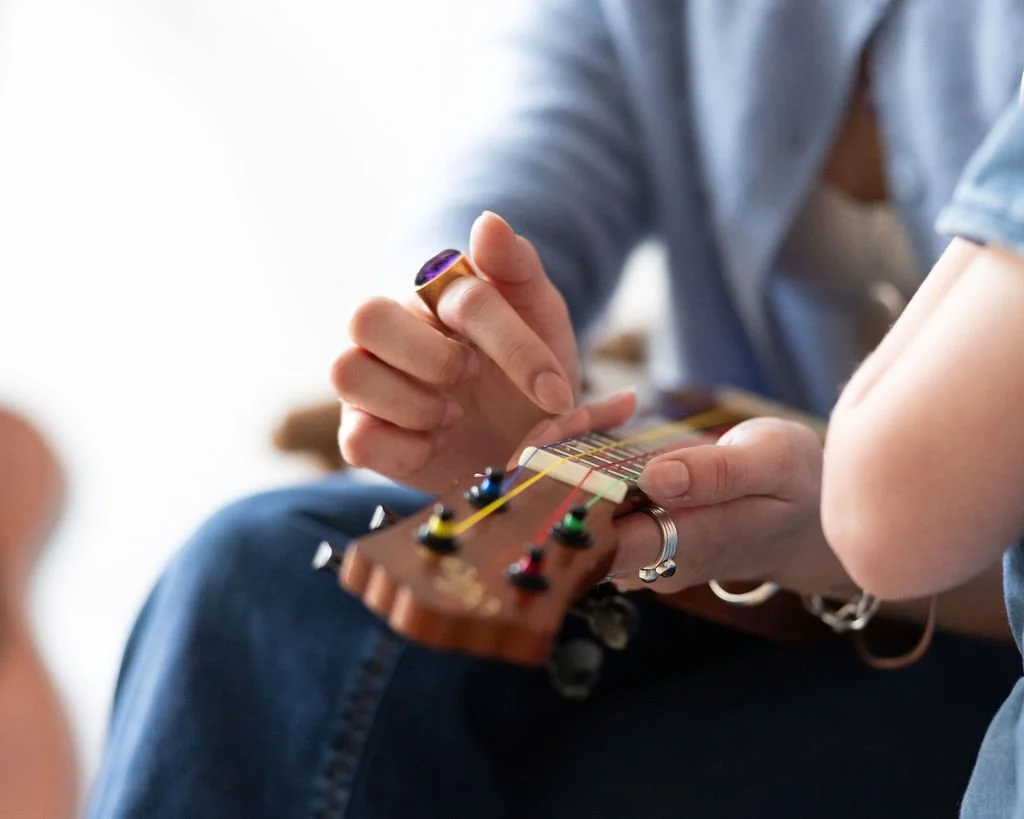 Child learning to play a guitar