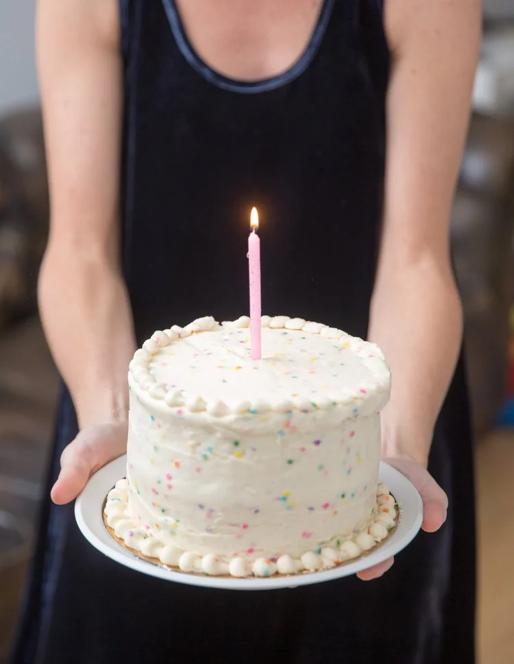 mom holding baby's first birthday cake