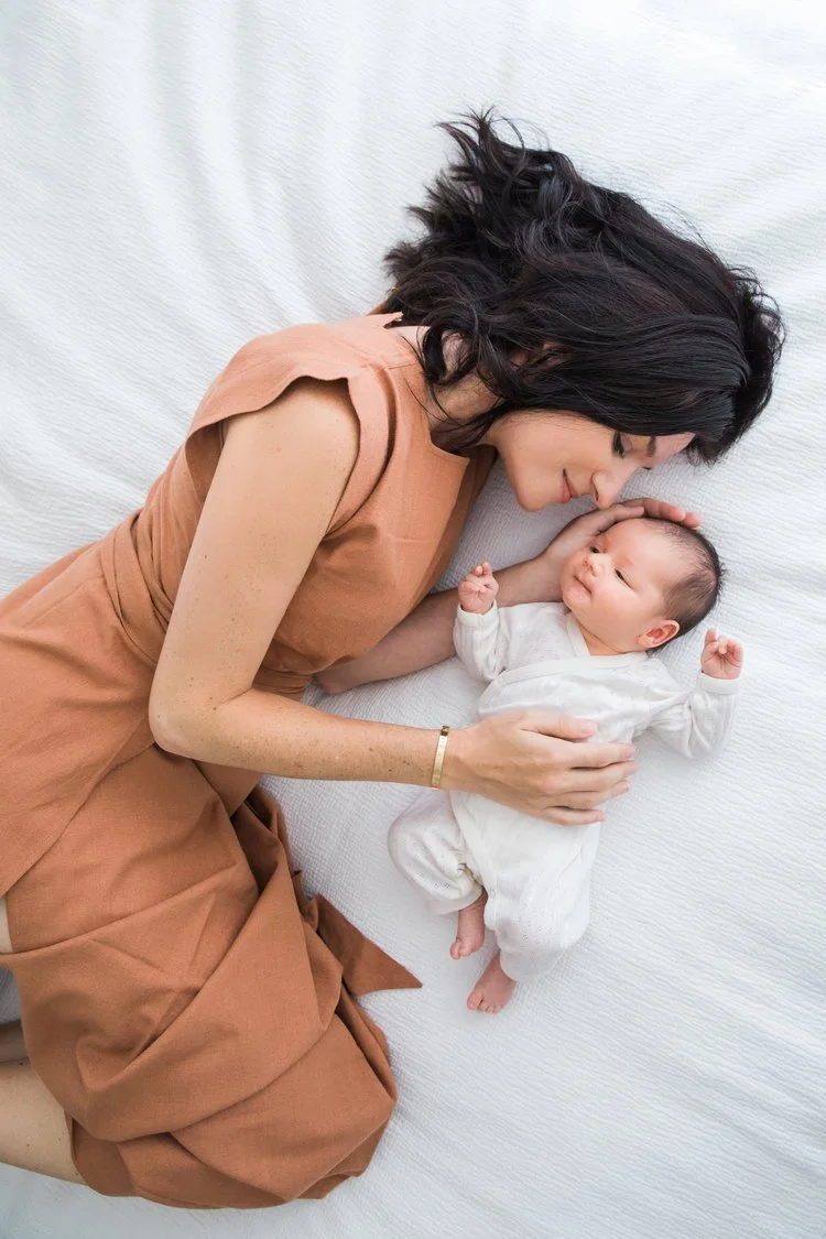 newborn baby at home with mom on bed