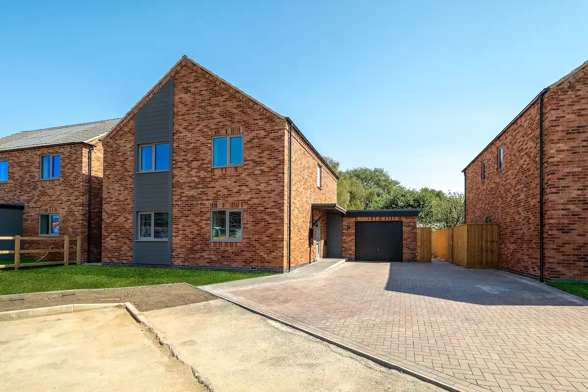A picture of a detached house with a garage and a private driveway
