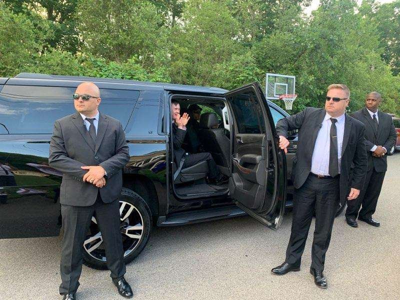 Kratos Security Group executive protection team beside a black SUV