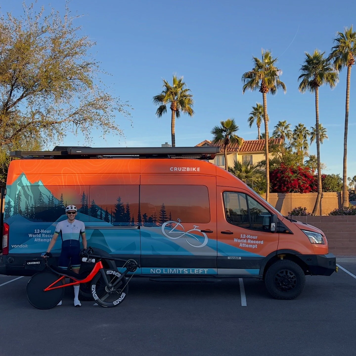 Matthew Lefthand stands with his recumbent bicycle in front of his support van