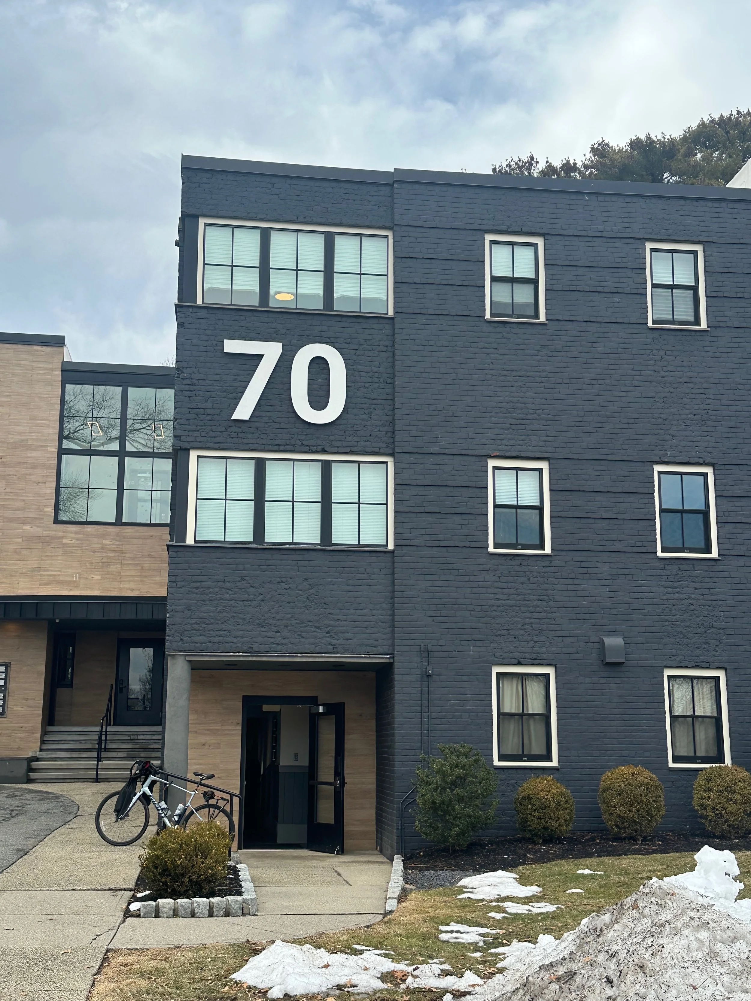photograph of the front of 70 park street, navy blue square building with handicap entrance in the very front.