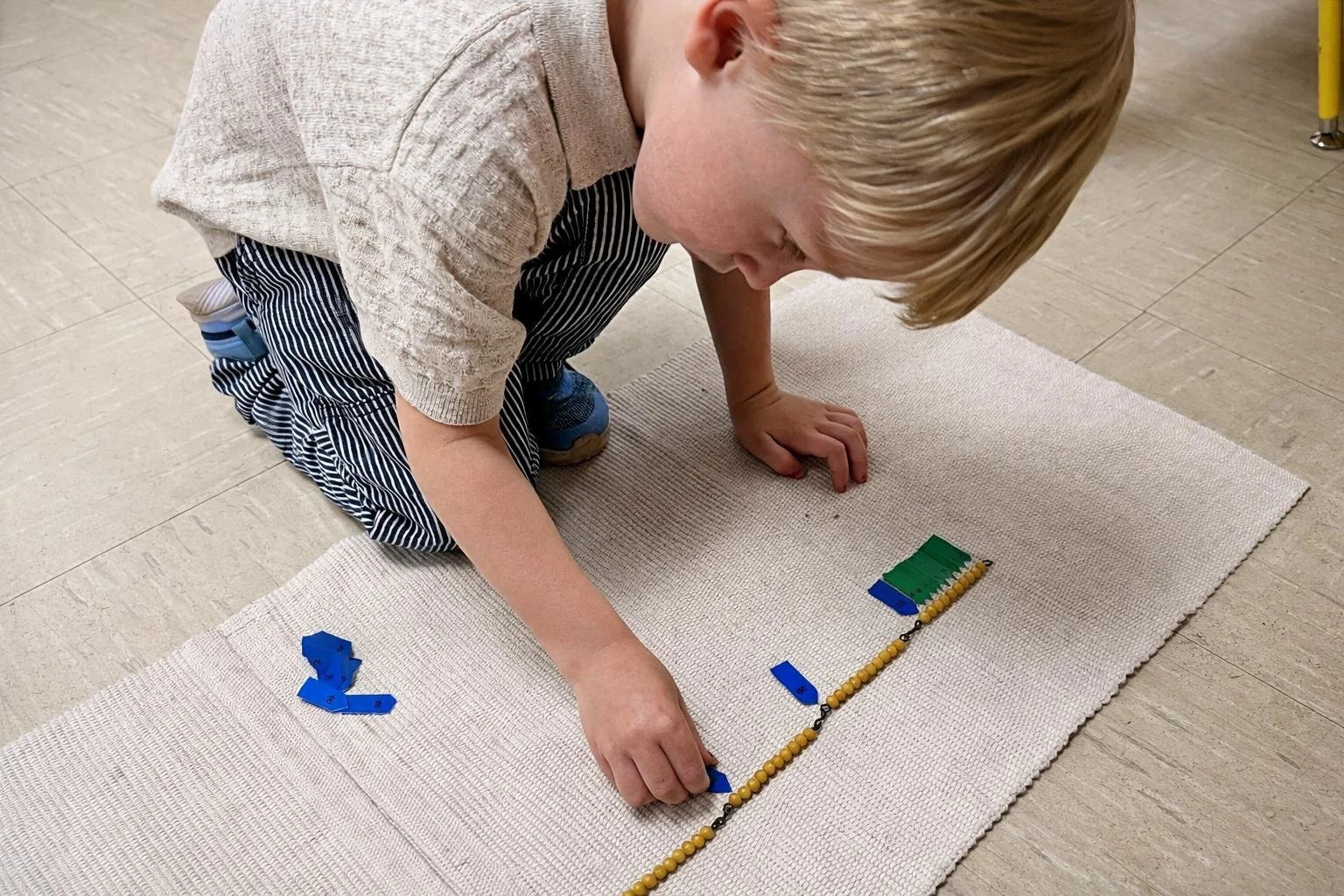 Montessori kindergarten student working with math materials in a Montessori classroom in Austin Texas