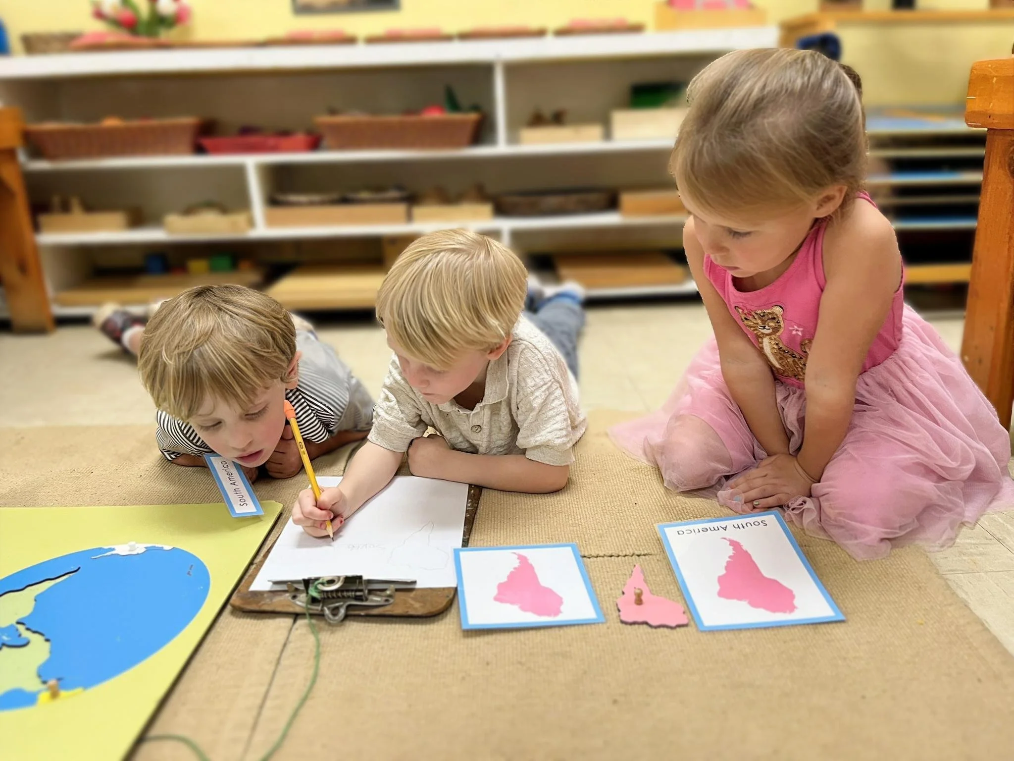 Kindergarten children engaged in hands-on Montessori learning in Austin, TX classroom