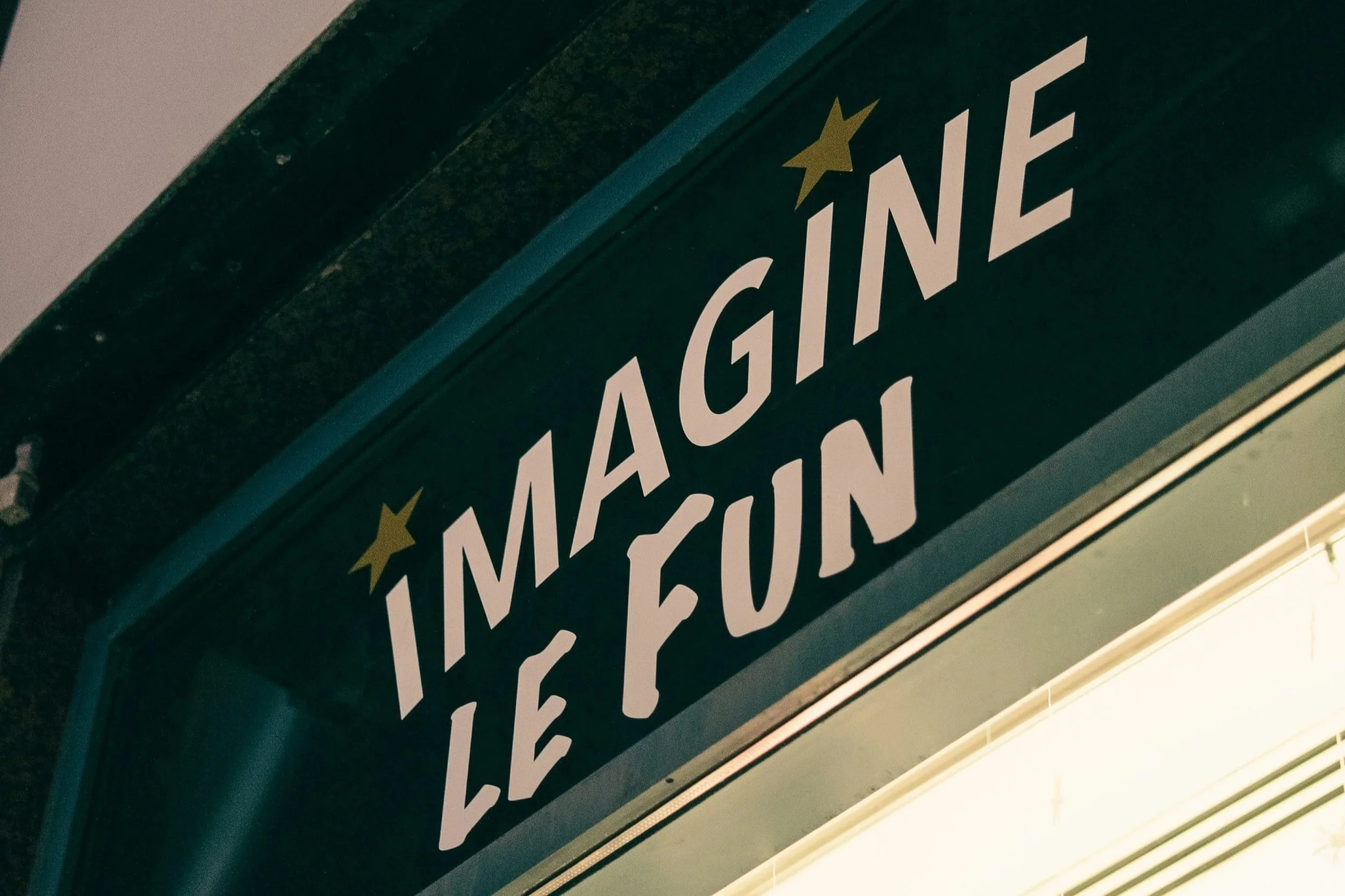Close-up of a green sign with white text and gold star accents.